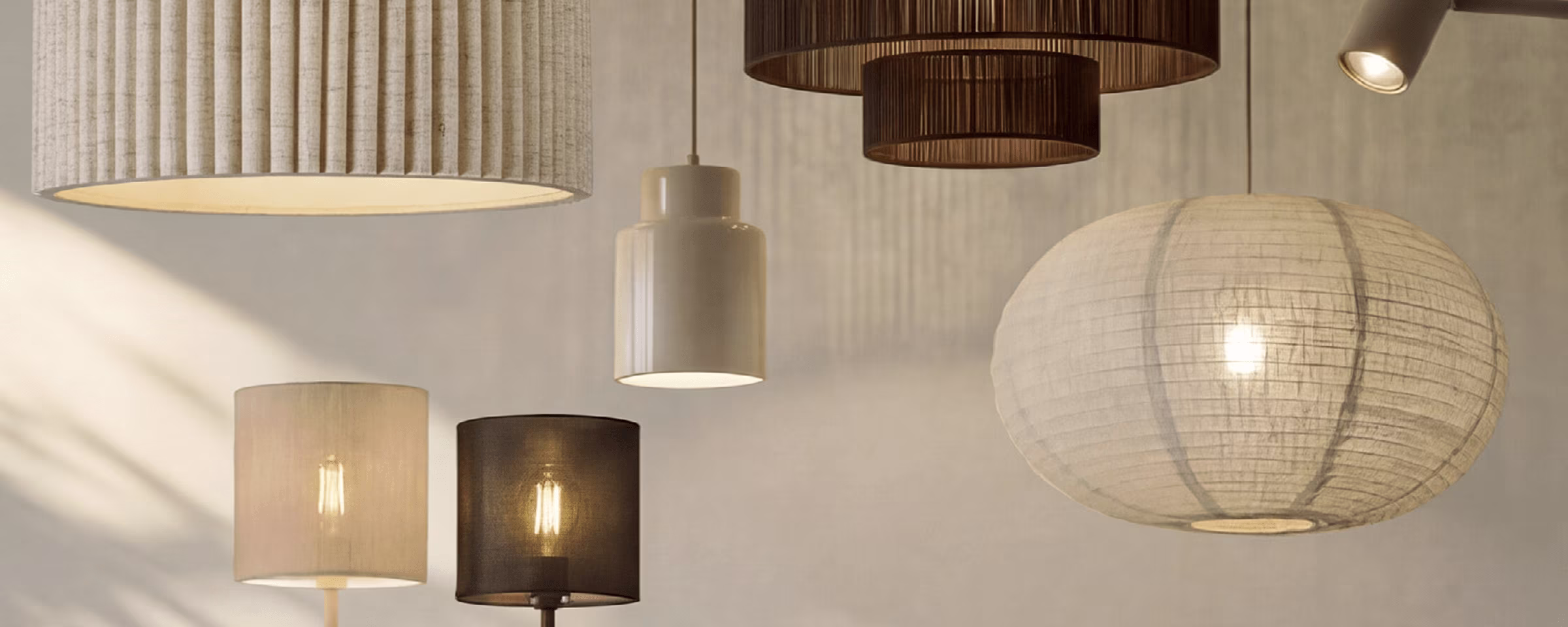 Verzameling van moderne lampen in neutrale tinten, waaronder hangende plafondlampen en staande lampen tegen een beige muur.