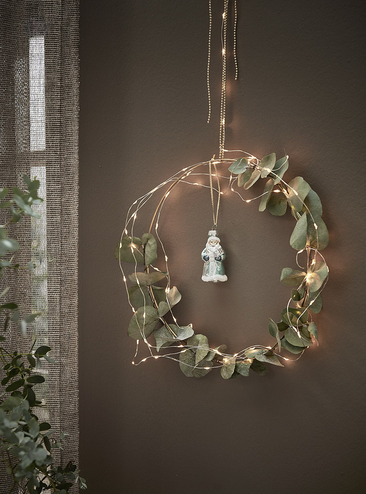 Een kerstkrans van eucalyptus met lampjes