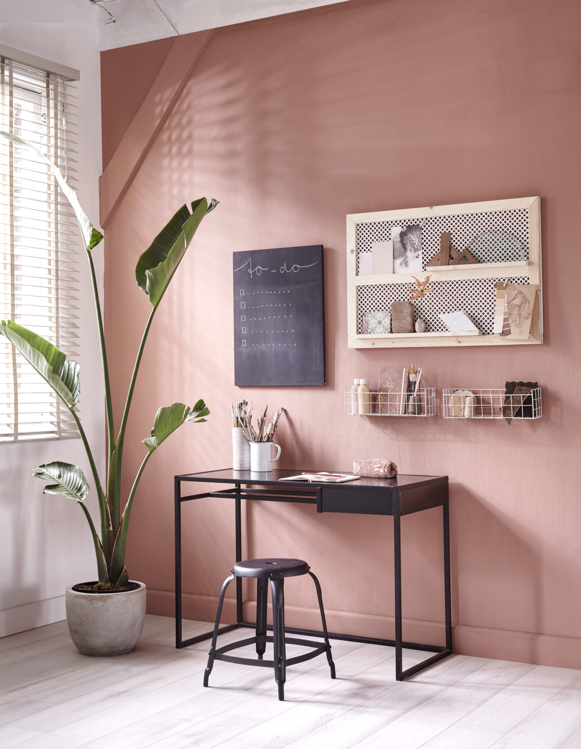 Houten wandbord bij werkplek met roze muur