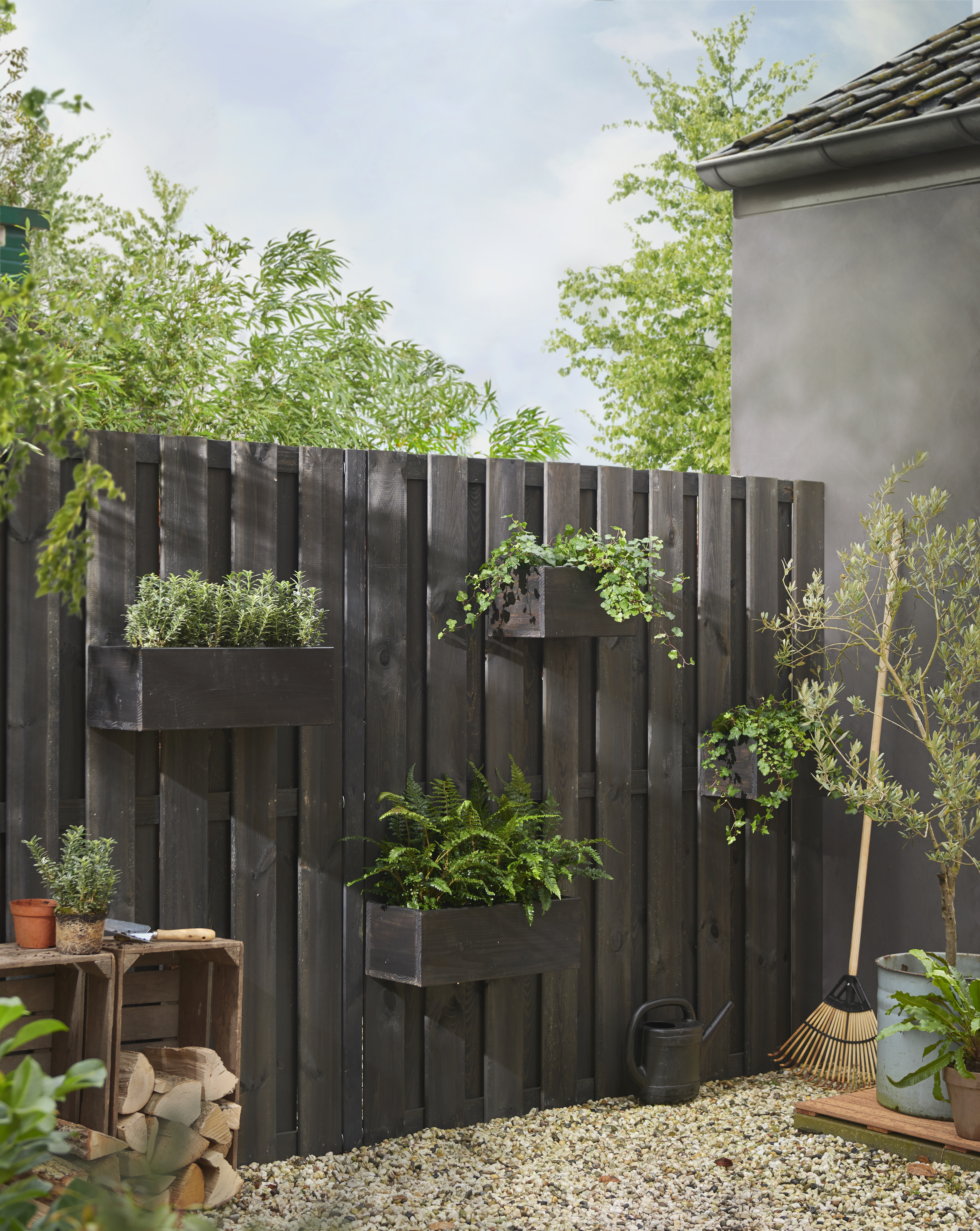 Donkere schutting met hangende plantenbakken