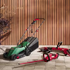 vrouw is een heg aan het snoeien met een heggenschaar