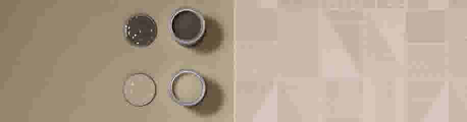 Twee open verfblikken van bovenaf gezien, één bruin en één beige, naast een geometrisch patroon behang in zandtinten.