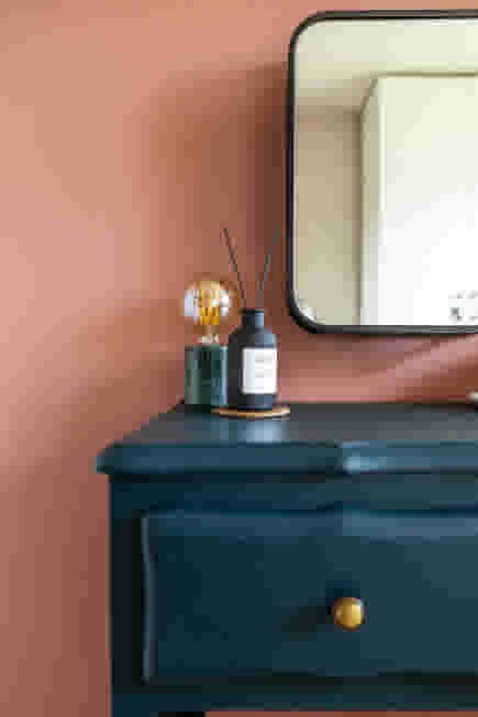 Donkerblauw nachtkastje met lampje en spiegel