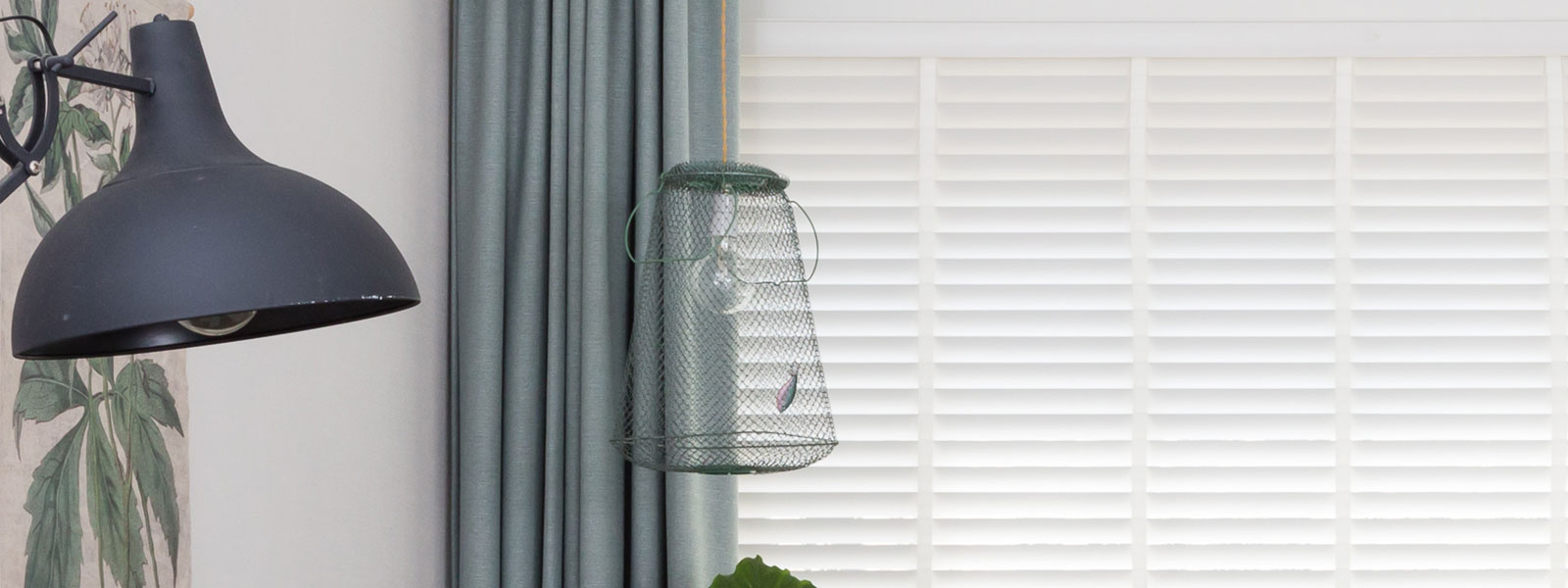 Visnet lamp hangend in een kamer naast een lamp met kap