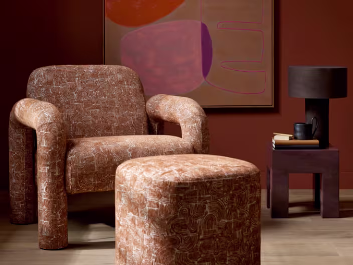 Moderne woonkamer met Theo-Bert Pot Collectie: fauteuil, poef, bijzettafel in warme tinten.