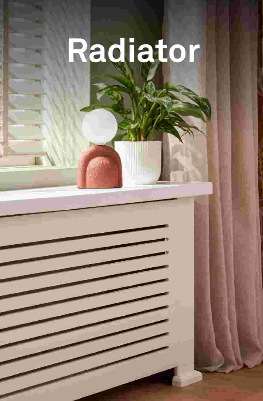 Een ingebouwde radiator met witte omhulsing met een mooie pot met bloemen