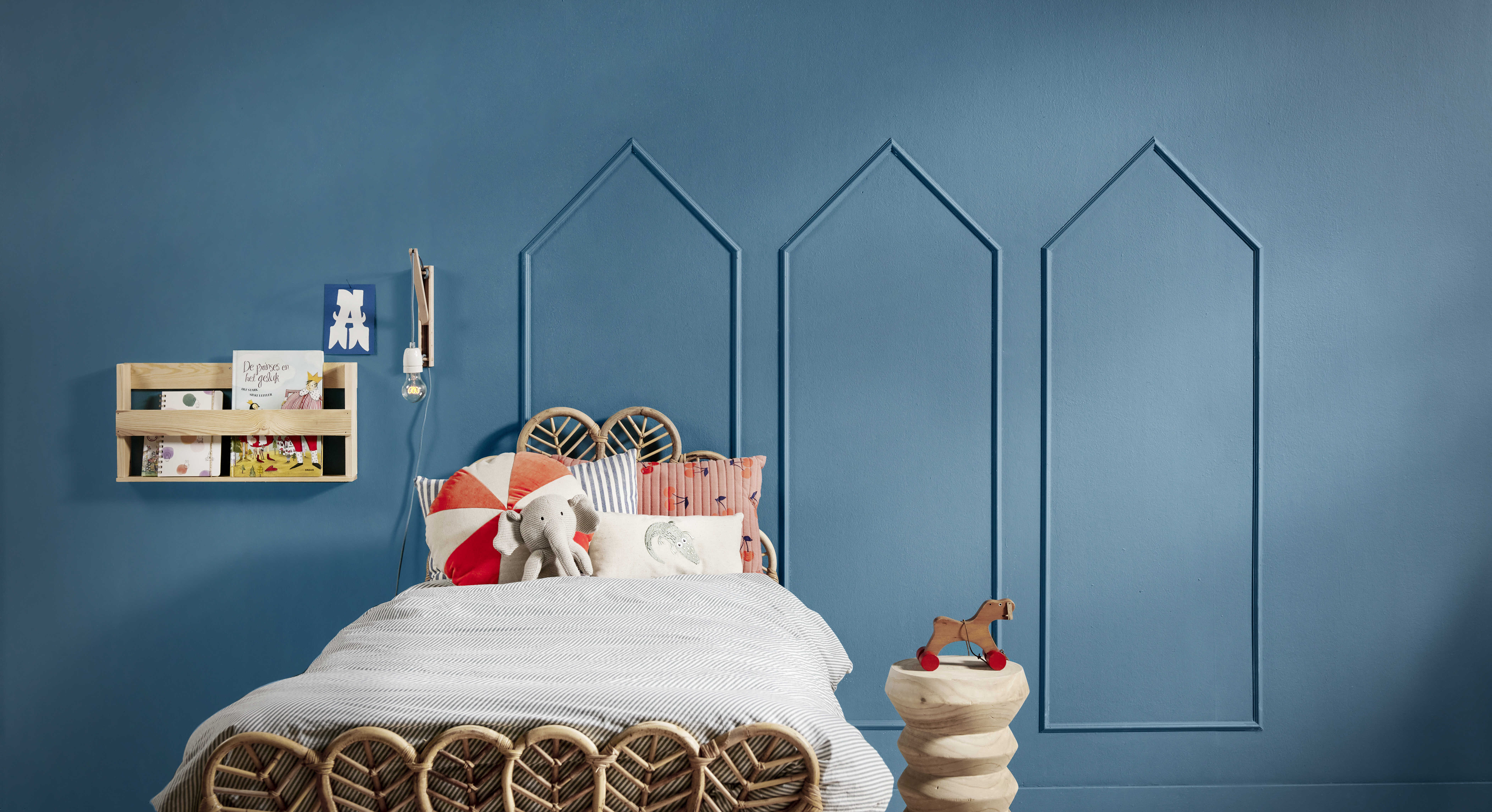 Huisjes van sierlijsten op blauwe wand