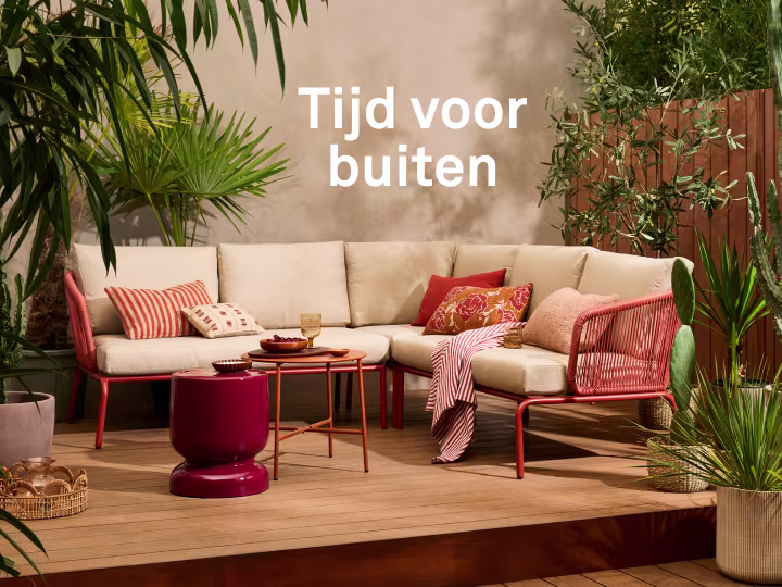 Gezin eet met elkaar aan een tuintafel. Karwei: lang leve het buitenleven.