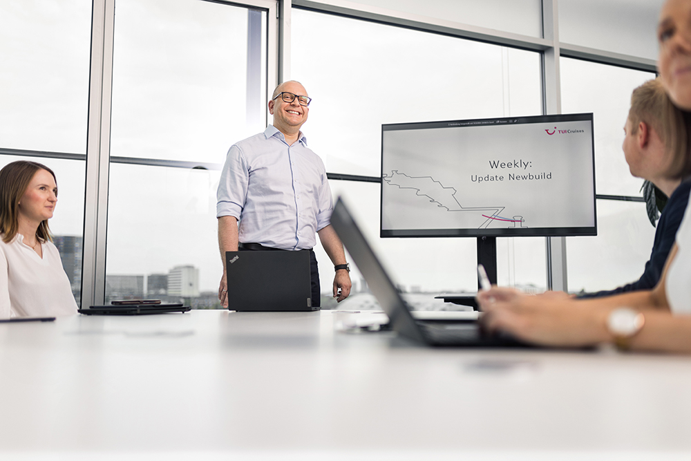 Person, die vor mehreren Menschen einen Vortrag hält 