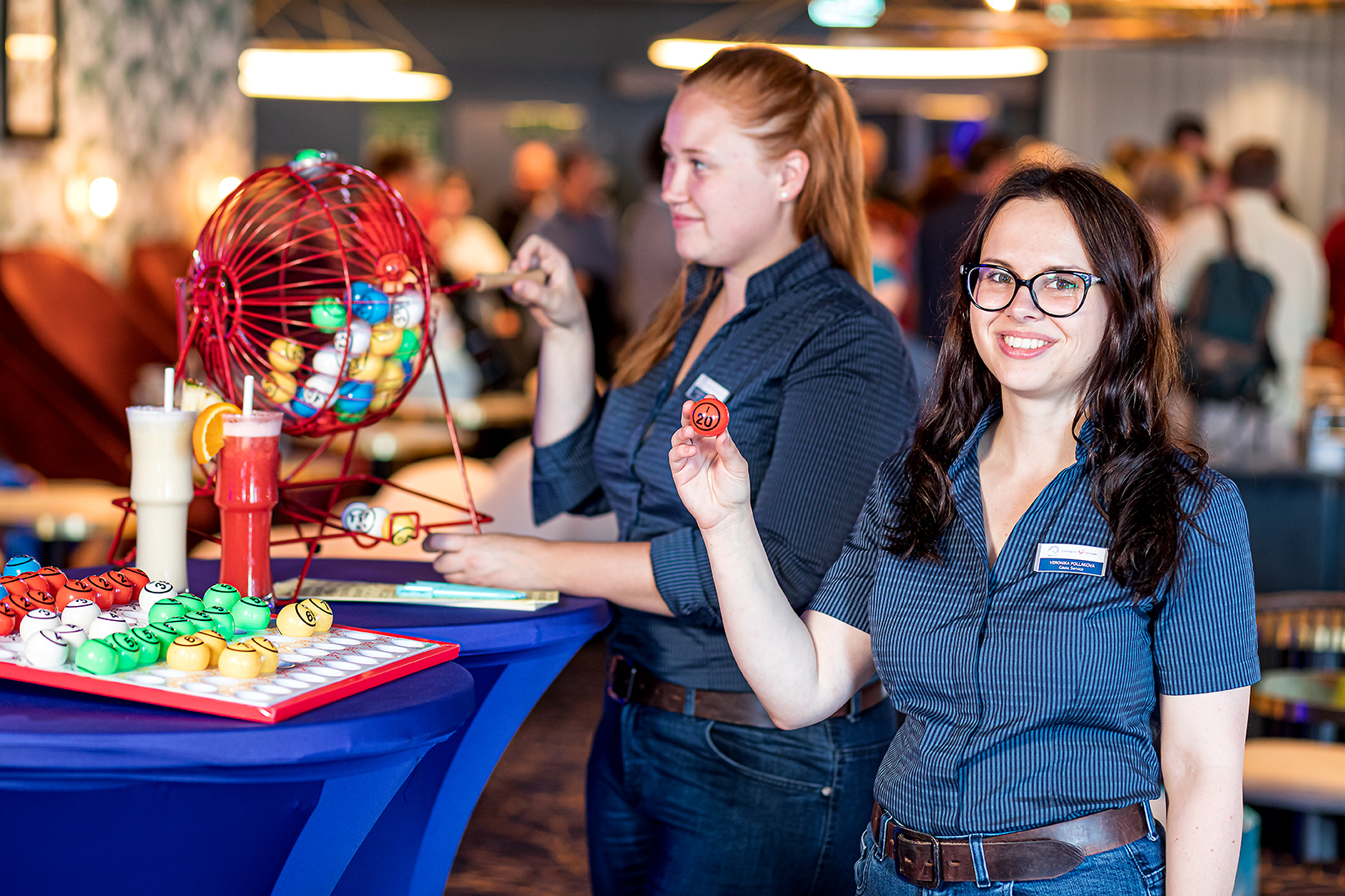 Zwei weibliche Crew-Mitglieder stehen vor einer Tombola