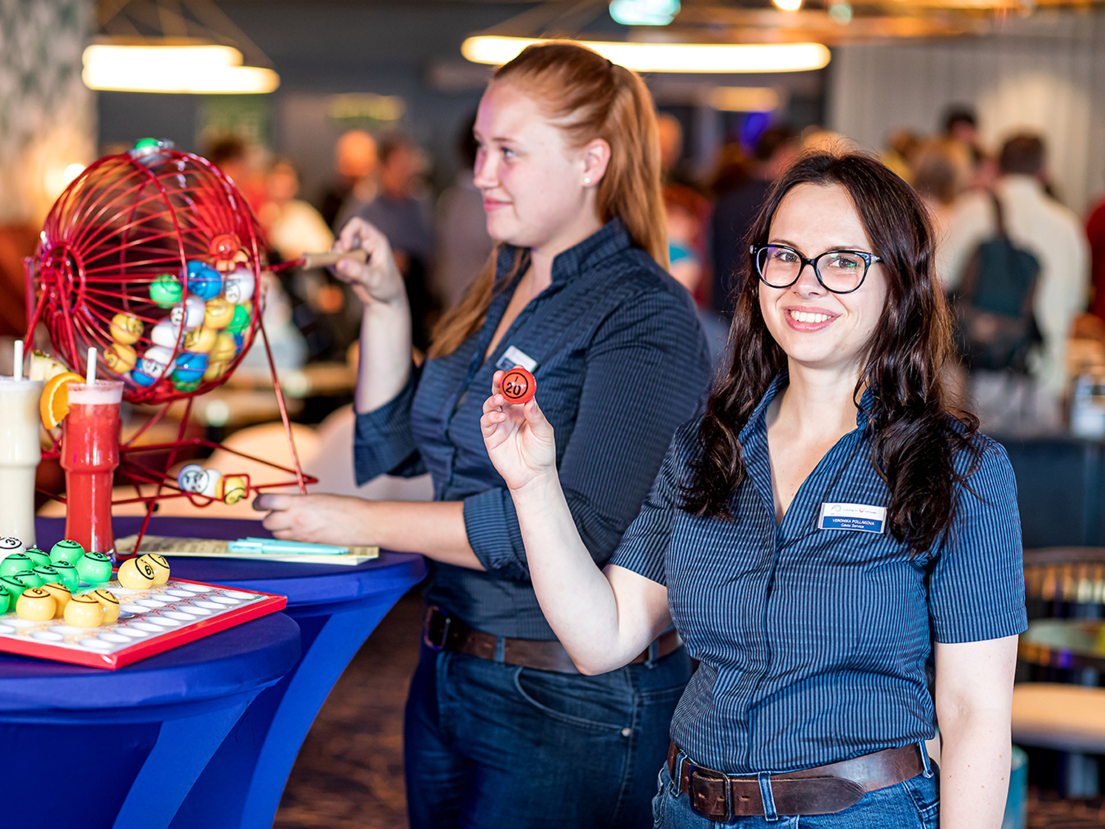 Zwei weibliche Crew-Mitglieder stehen vor einer Tombola