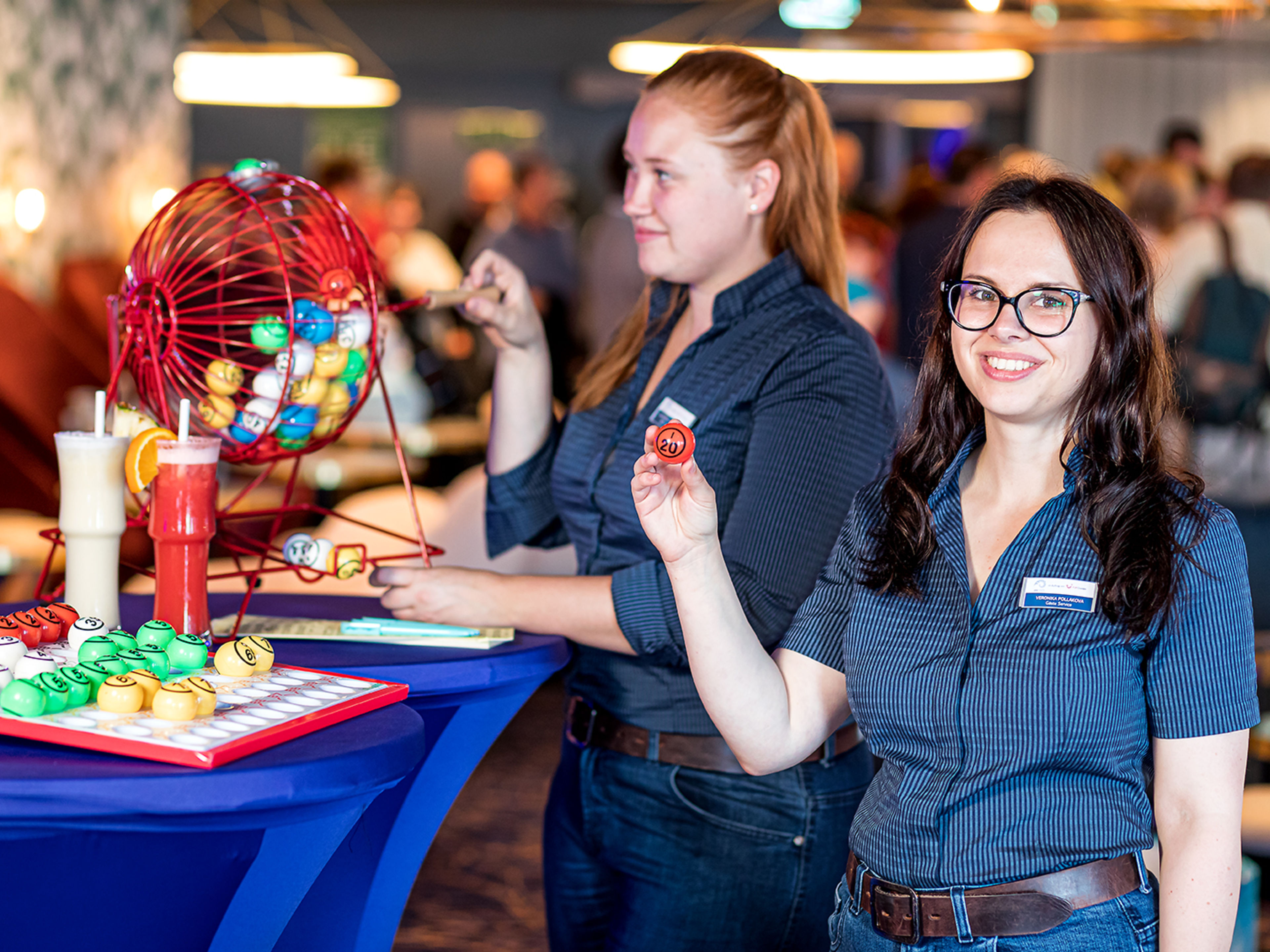 Zwei weibliche Crew-Mitglieder stehen vor einer Tombola