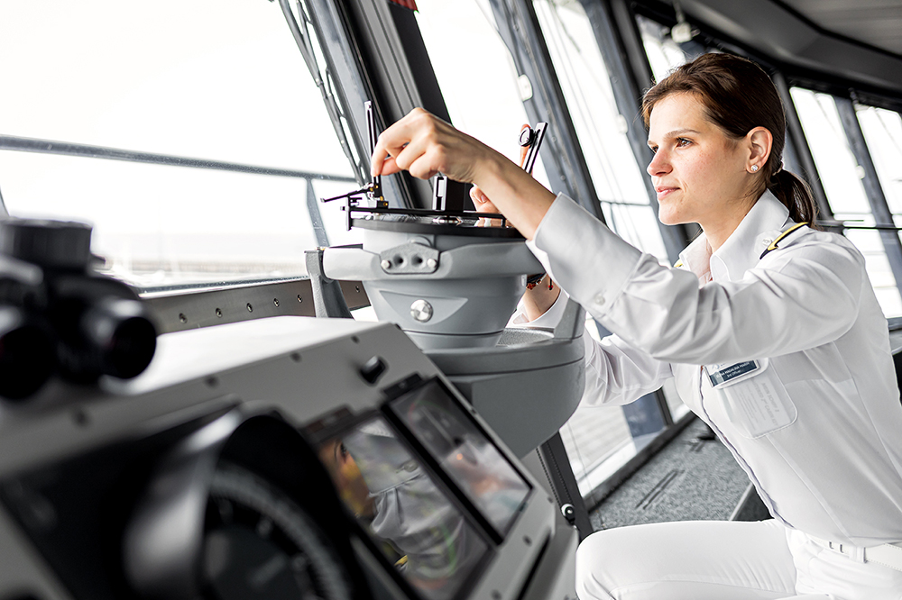 Schiffsbrücke. eine weibliche Offizierin arbeitet konzentriert an einem Navigationsinstrument