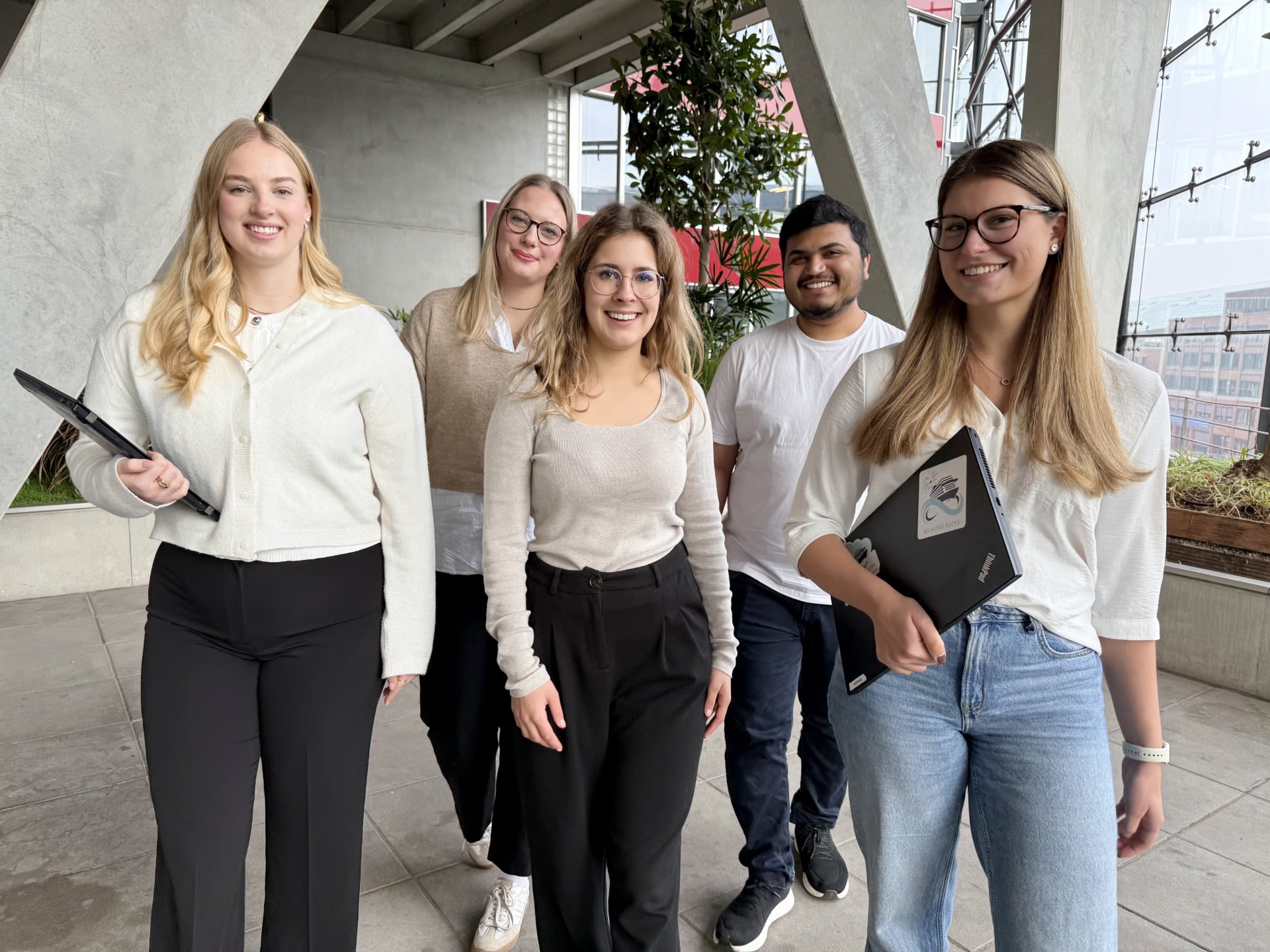 Drei Personen nebeneinander, die lächeln 