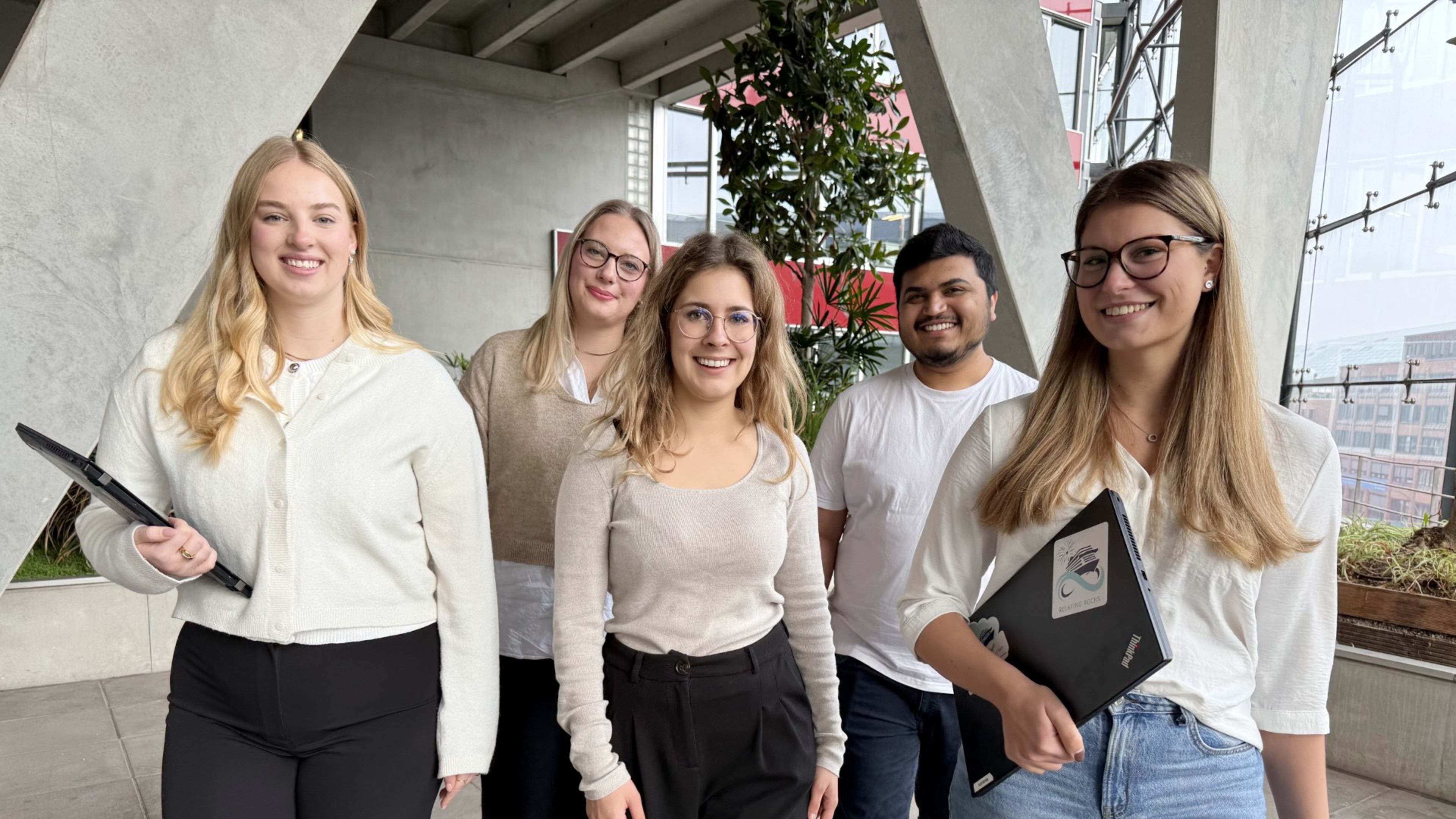 Drei Personen nebeneinander, die lächeln