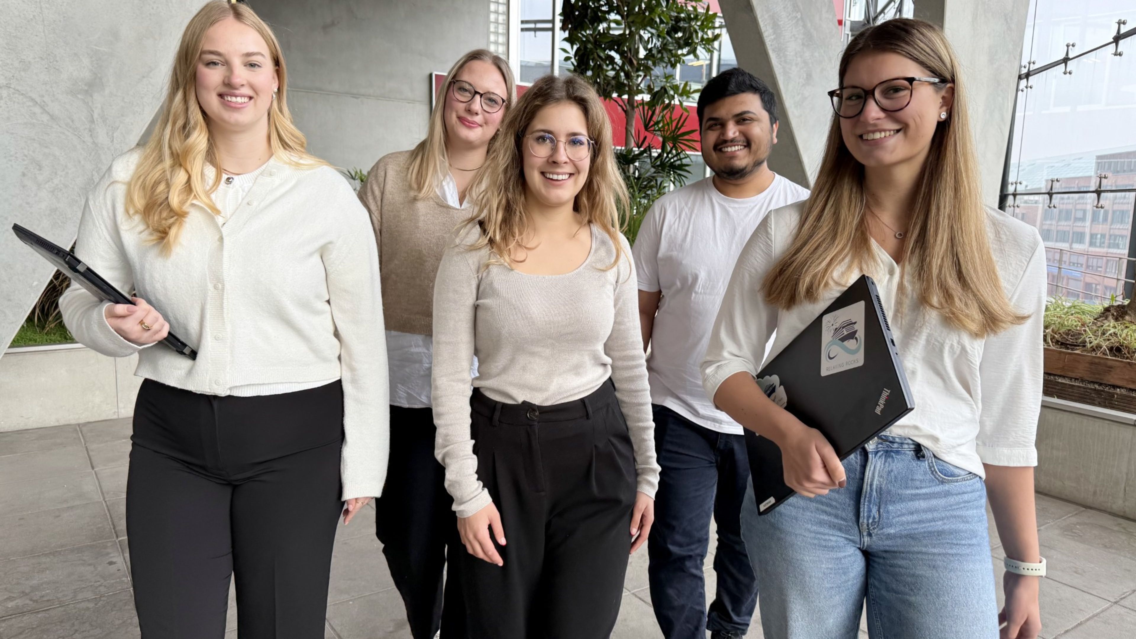 Drei Personen nebeneinander, die lächeln