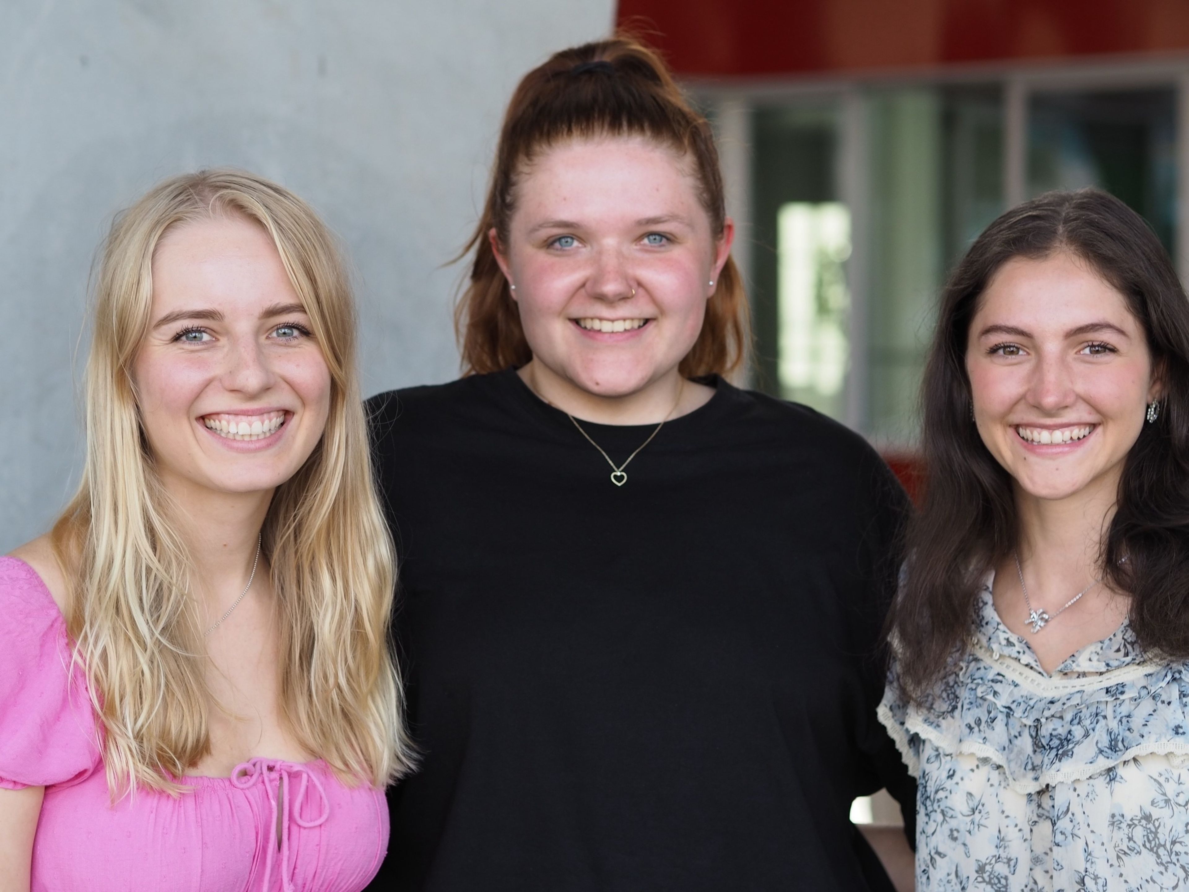 Drei weibliche Azubis, die in die Kamera lächeln