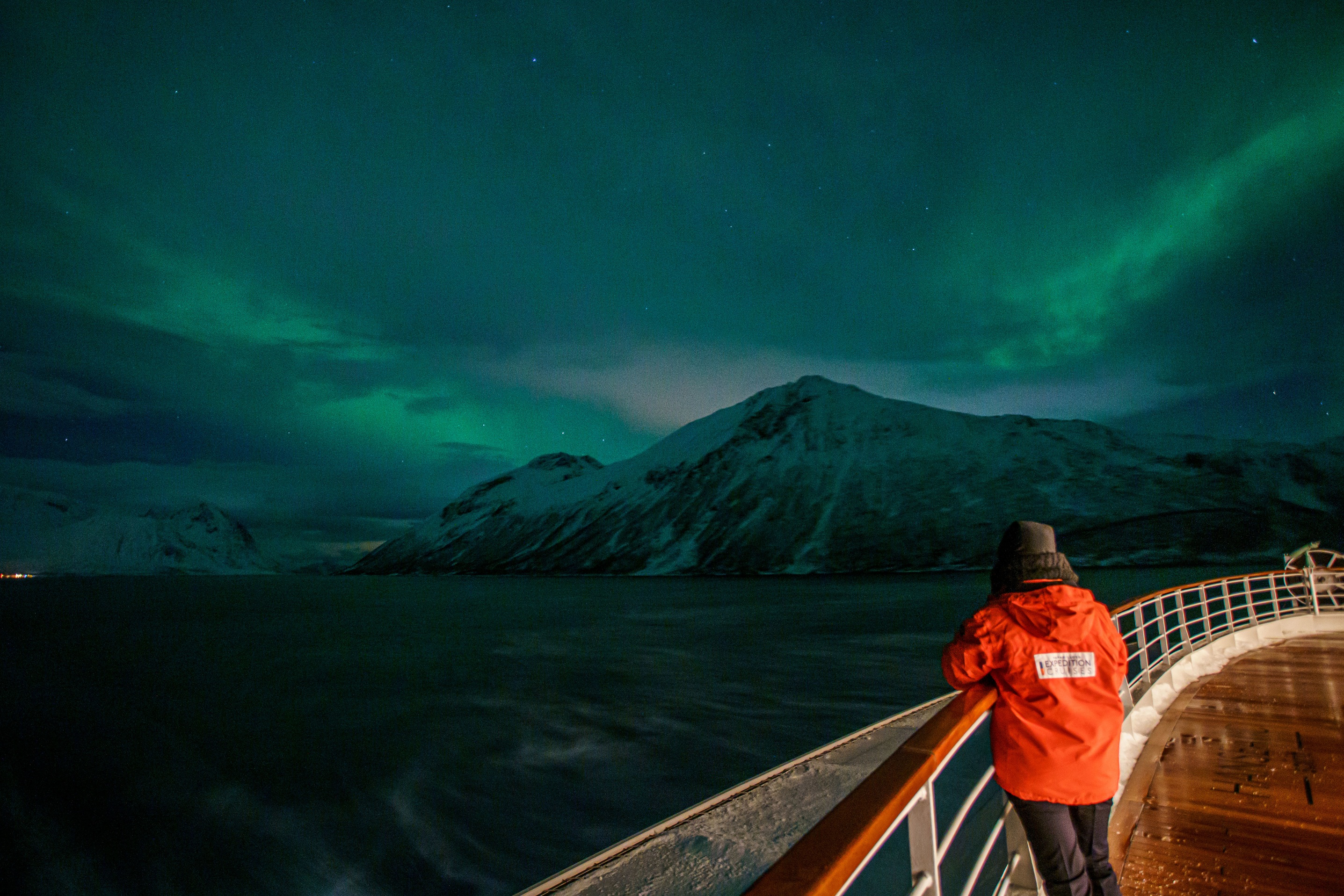 Eine Person beobachtet die Polarlichter an Bord eines Expeditionsschiffs von Hapag-Lloyd Cruises 