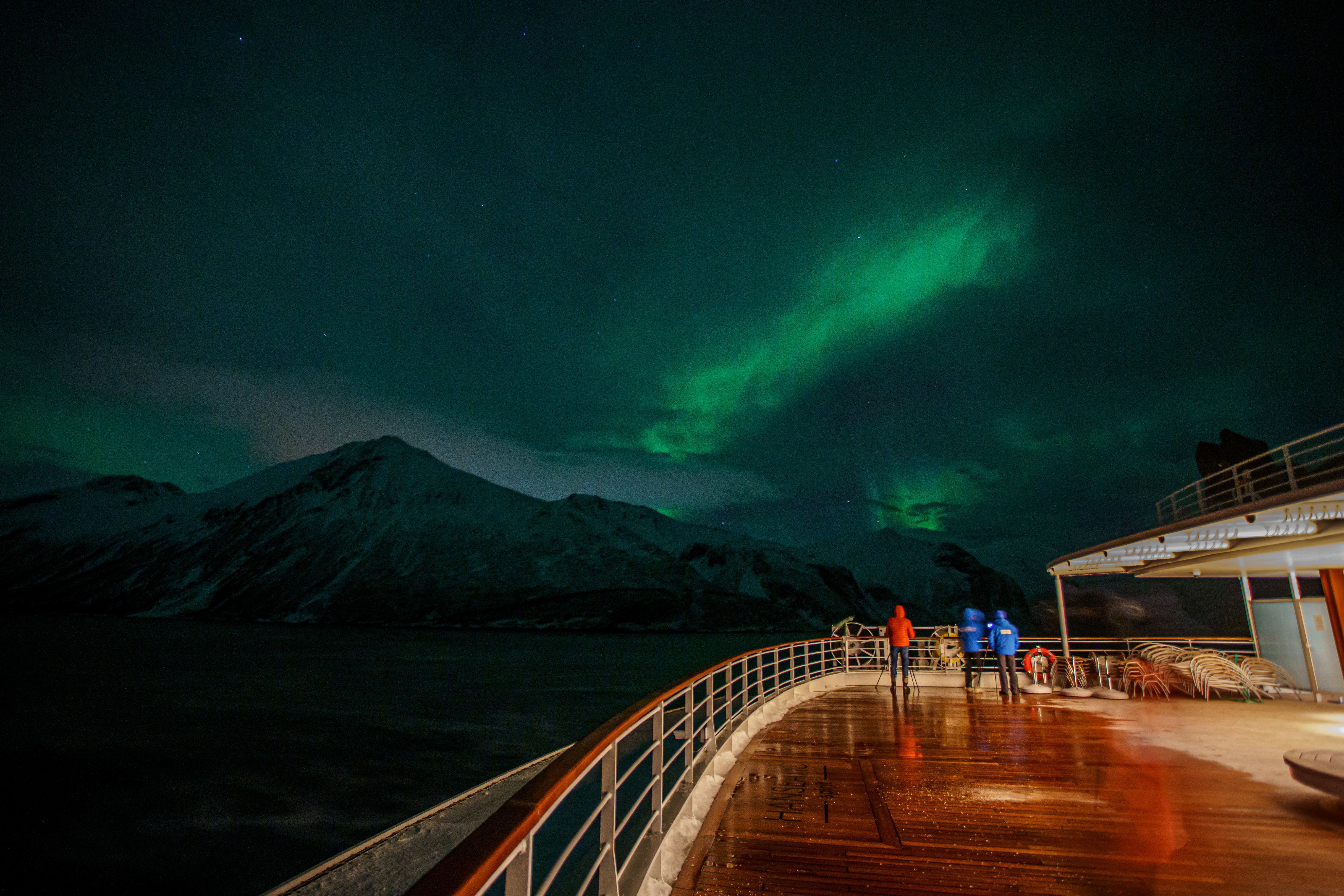 Guests watch the Northern Lights from the deck of the HANSEATIC spirit.