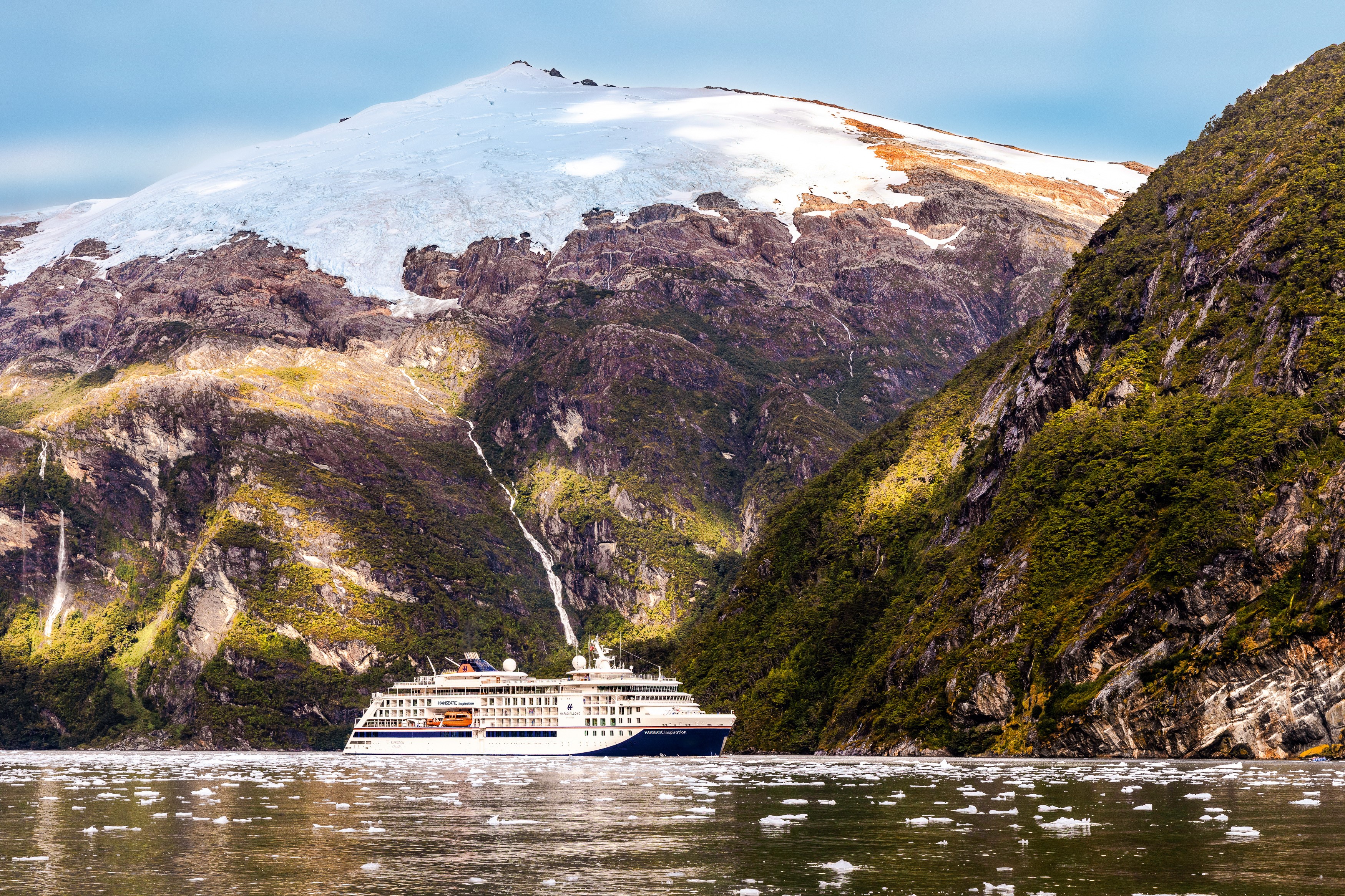 Majestätische Fahrt durch die chilenischen Fjorde: Die HANSEATIC inspiration gleitet vorbei an schneebedeckten Bergen und malerischen Wasserfällen. Ein unvergleichliches Naturerlebnis erwartet die Gäste.