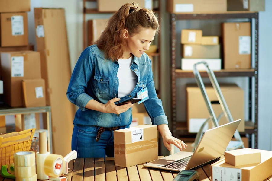 Woman with a laptop and packing boxes.