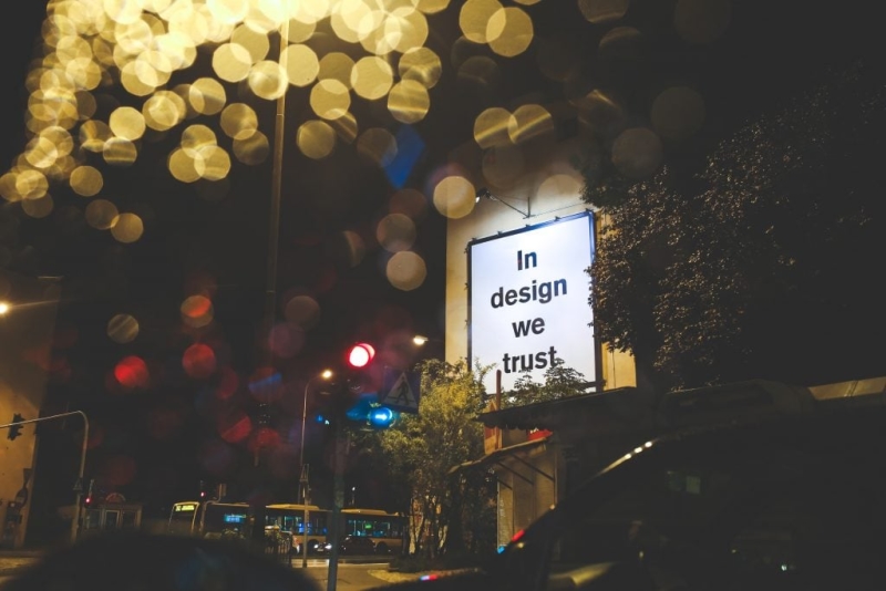 A picture of a sign outside reading "in design we trust"