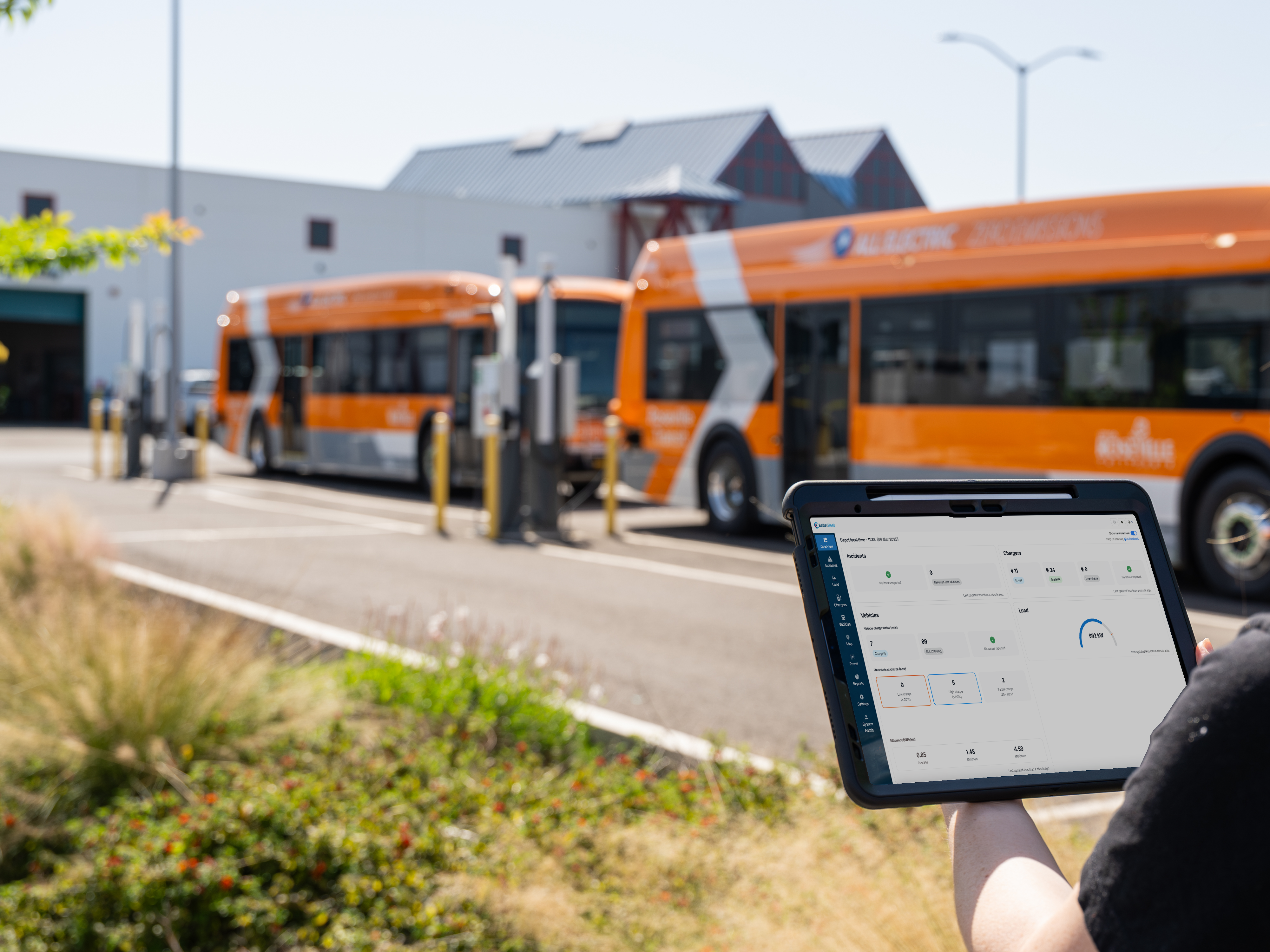 Betterfleet user looking at betterfleet dashboard in front of buses.