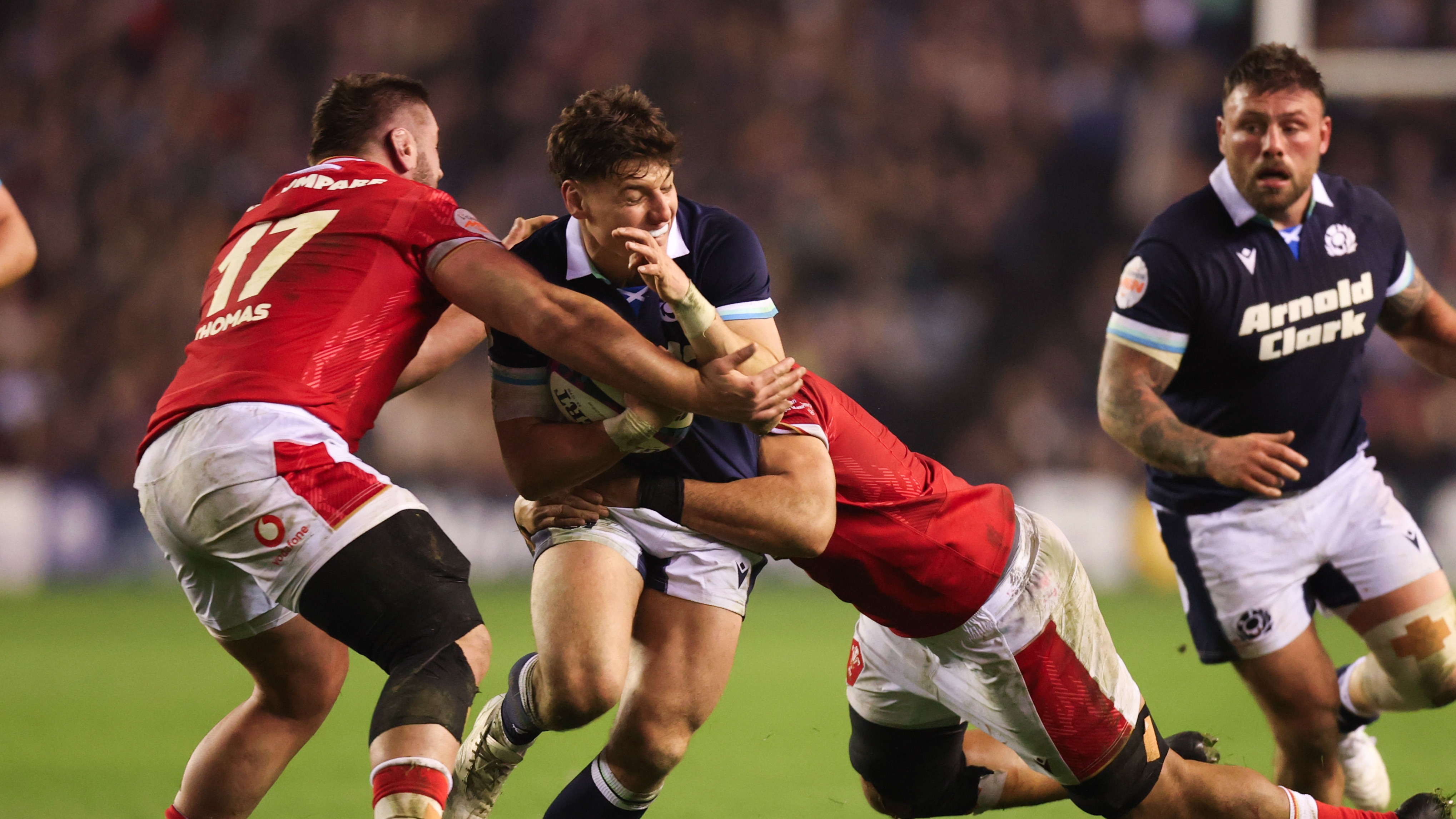 Scotland's Tom Jordan is tackled by Gareth Thomas and Taulupe Faletau of Wales during the 2025 Six Nations Championship.