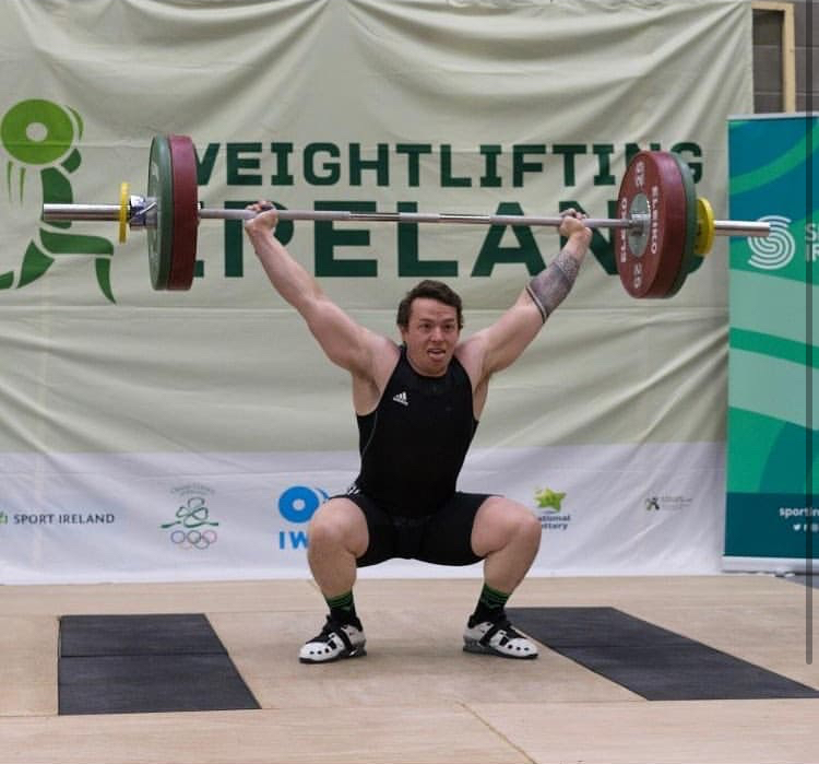 Man performing an Olympic lift, snatch.