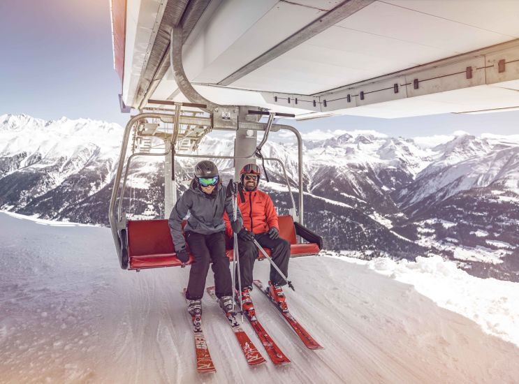 Zwei Skifahrer steigen von einem Skilift ab, Wallis, Schweiz