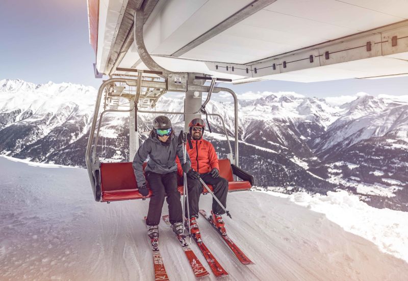 Two skiers descend from a ski lift, Valais, Switzerland