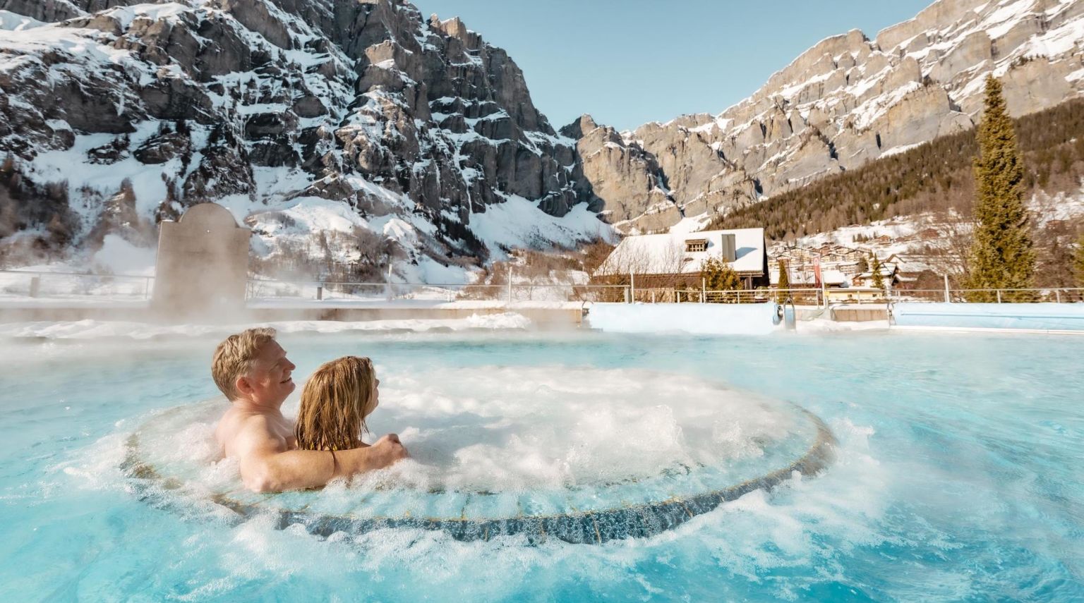 Two people admiring the view from the thermal baths of Leukerbad. Valais, Switzerland