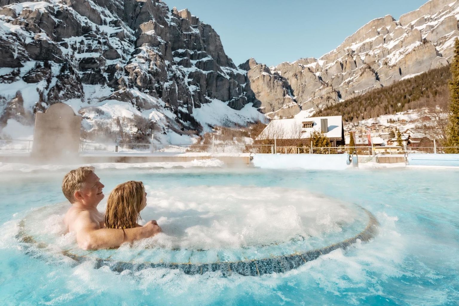 Deux personnes admirent la vue depuis les bains thermaux de Leukerbad. Valais, Suisse
