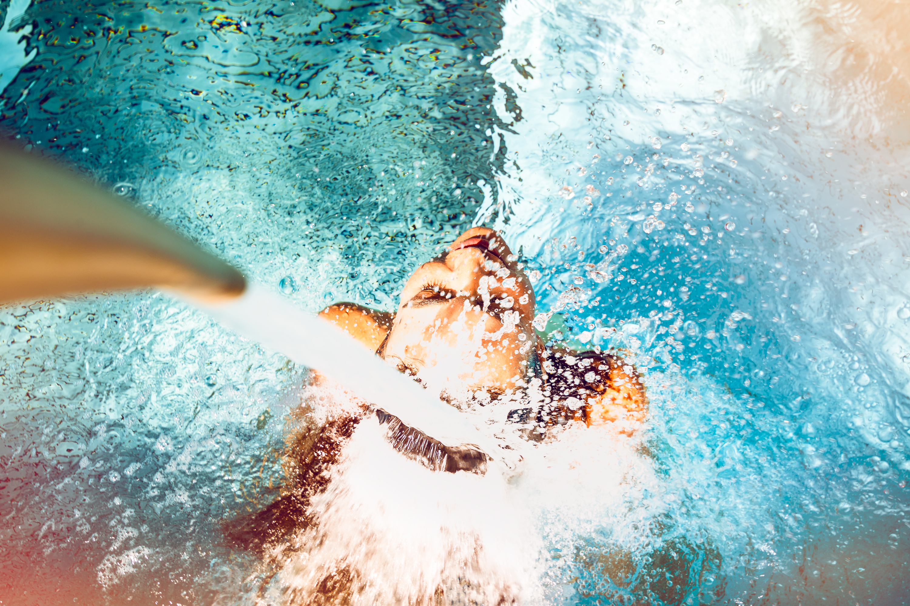 Ein Mädchen unter einem Jet aus den Bädern von Saillon. Wallis, Schweiz.