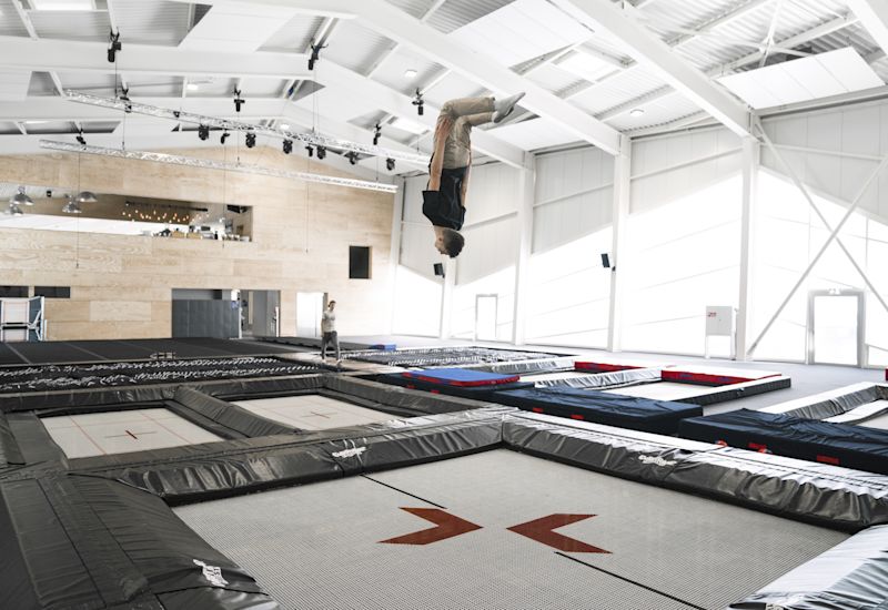 Gymnaste effectuant un salto au trampoline à l'Alaïcha Chalet, Valais Wallis Schweiz