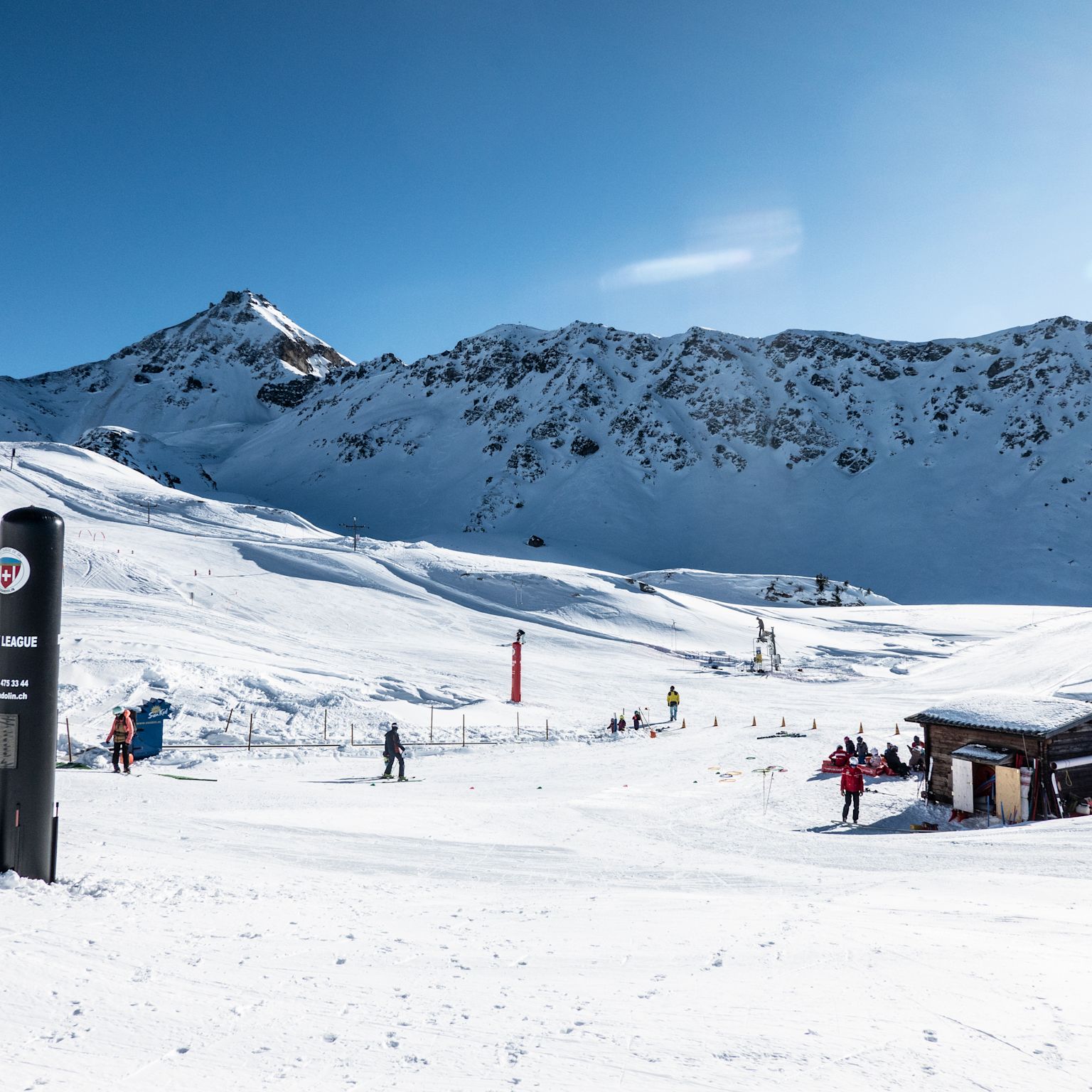 Beginner snow garden in Chandolin with conveyor lift, gentle slope and children skiing under the sun