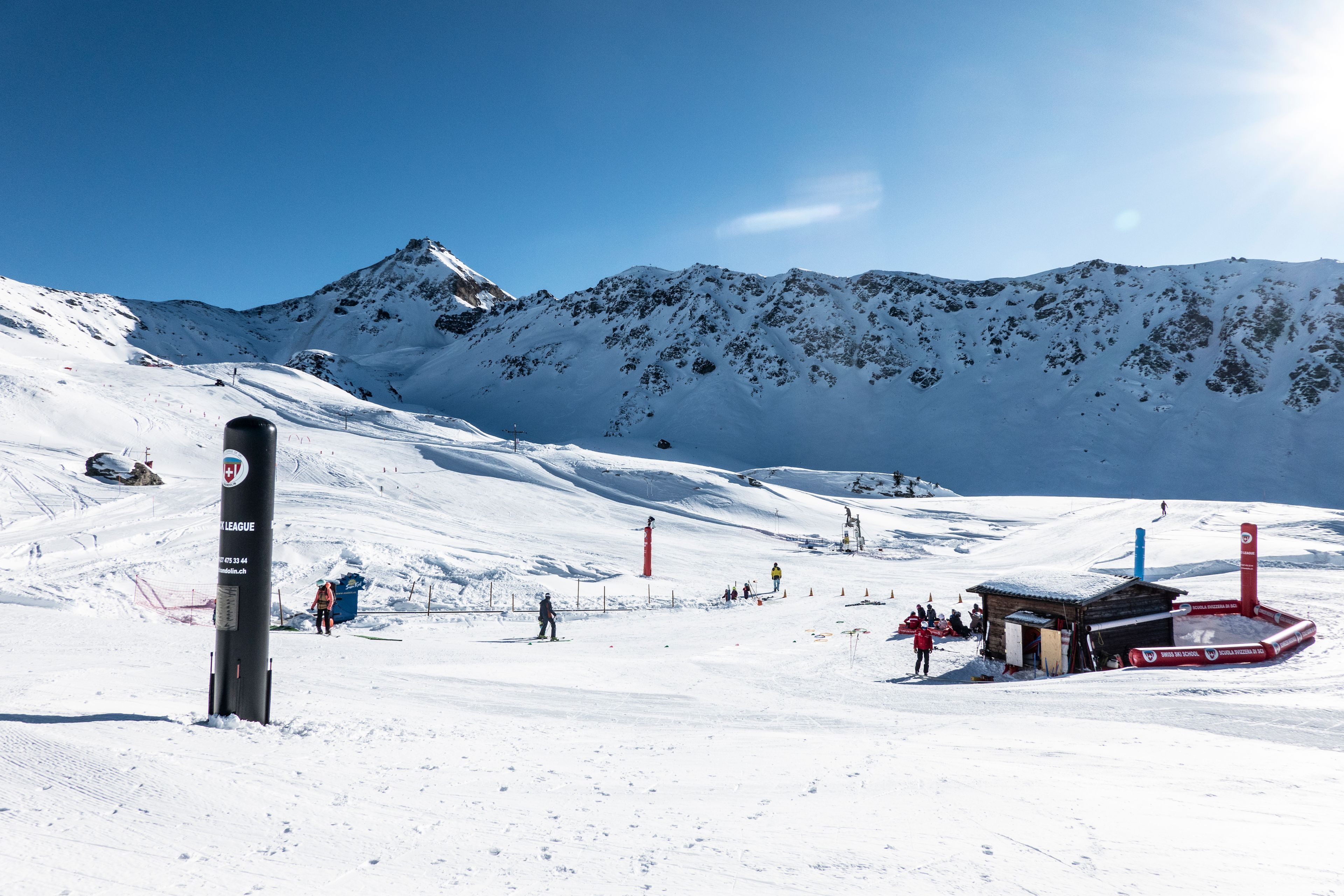 Beginner snow garden in Chandolin with conveyor lift, gentle slope and children skiing under the sun
