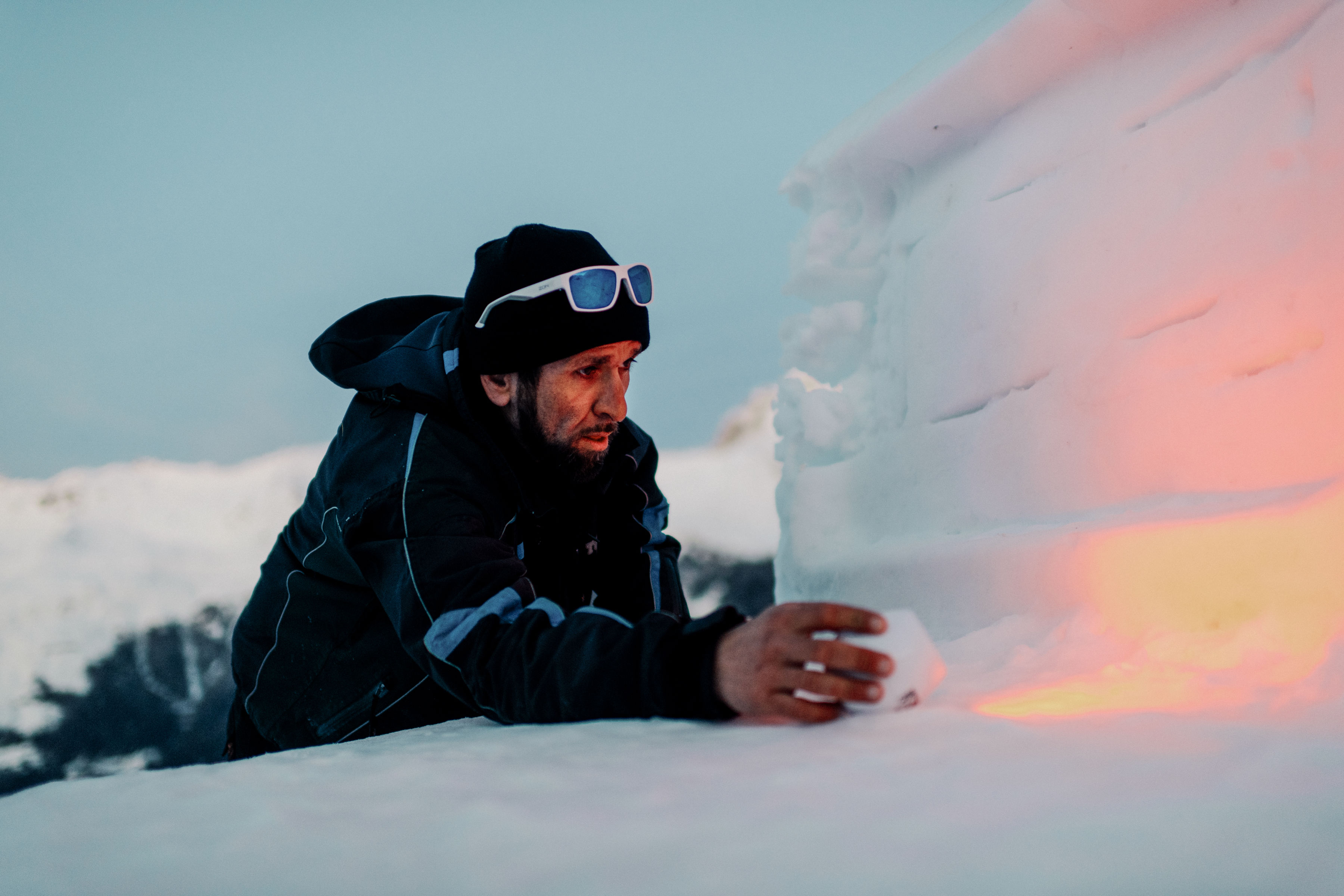 Nach seinem Dienst am Skilift verweilt Marcio oft noch einen Moment bei seiner Schneeskulptur, Wallis, Schweiz