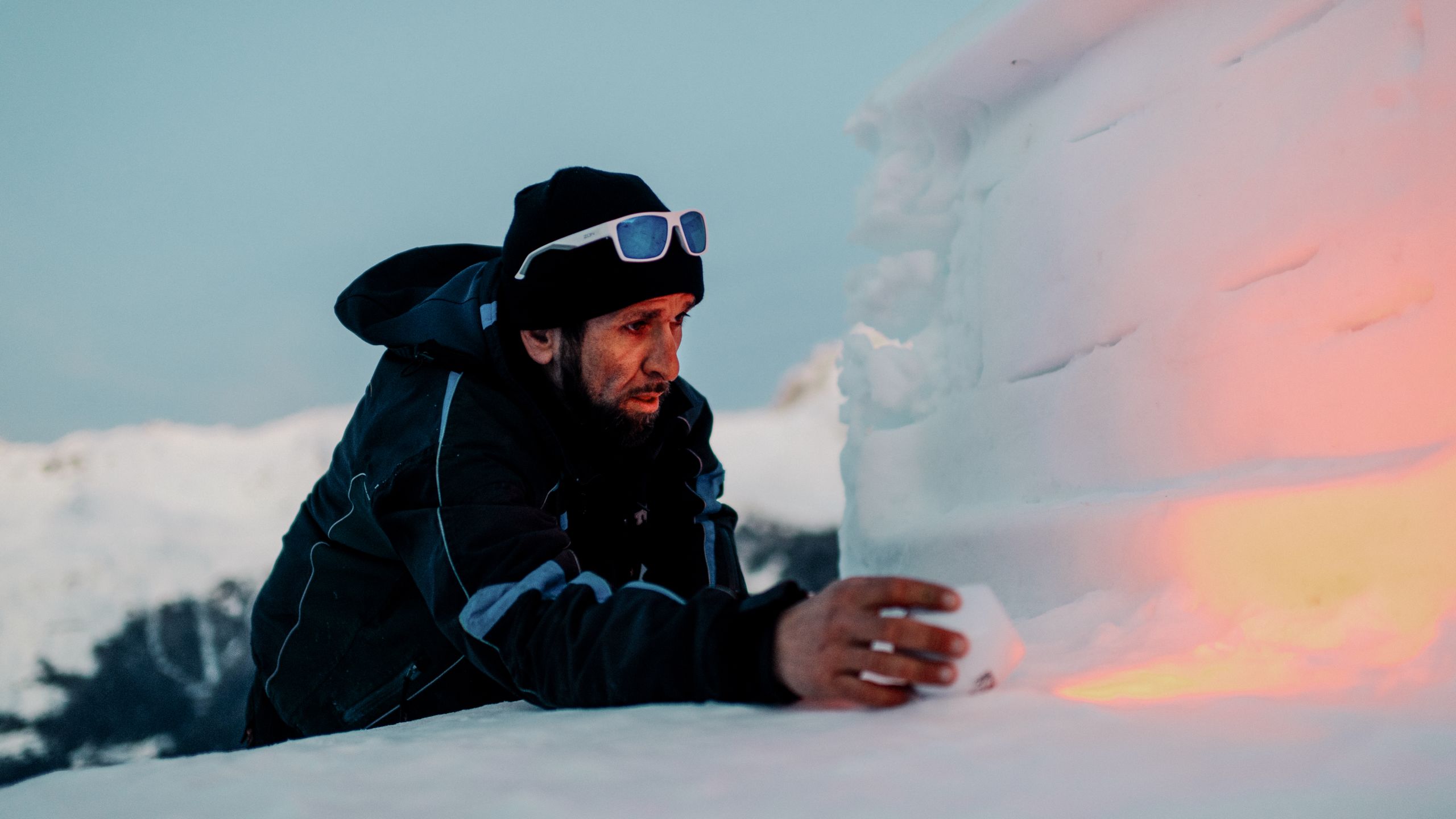 Nach seinem Dienst am Skilift verweilt Marcio oft noch einen Moment bei seiner Schneeskulptur, Wallis, Schweiz