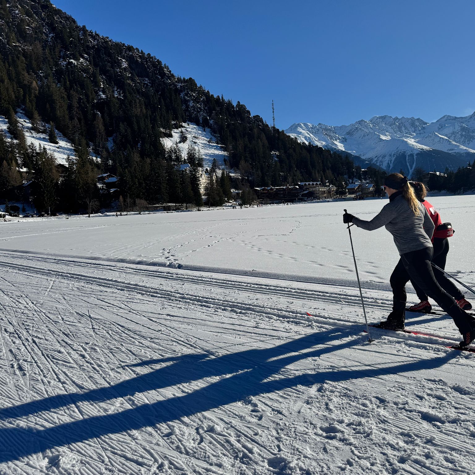Two cross-country skiers on a trail in the winter landscape of Champex-Lac