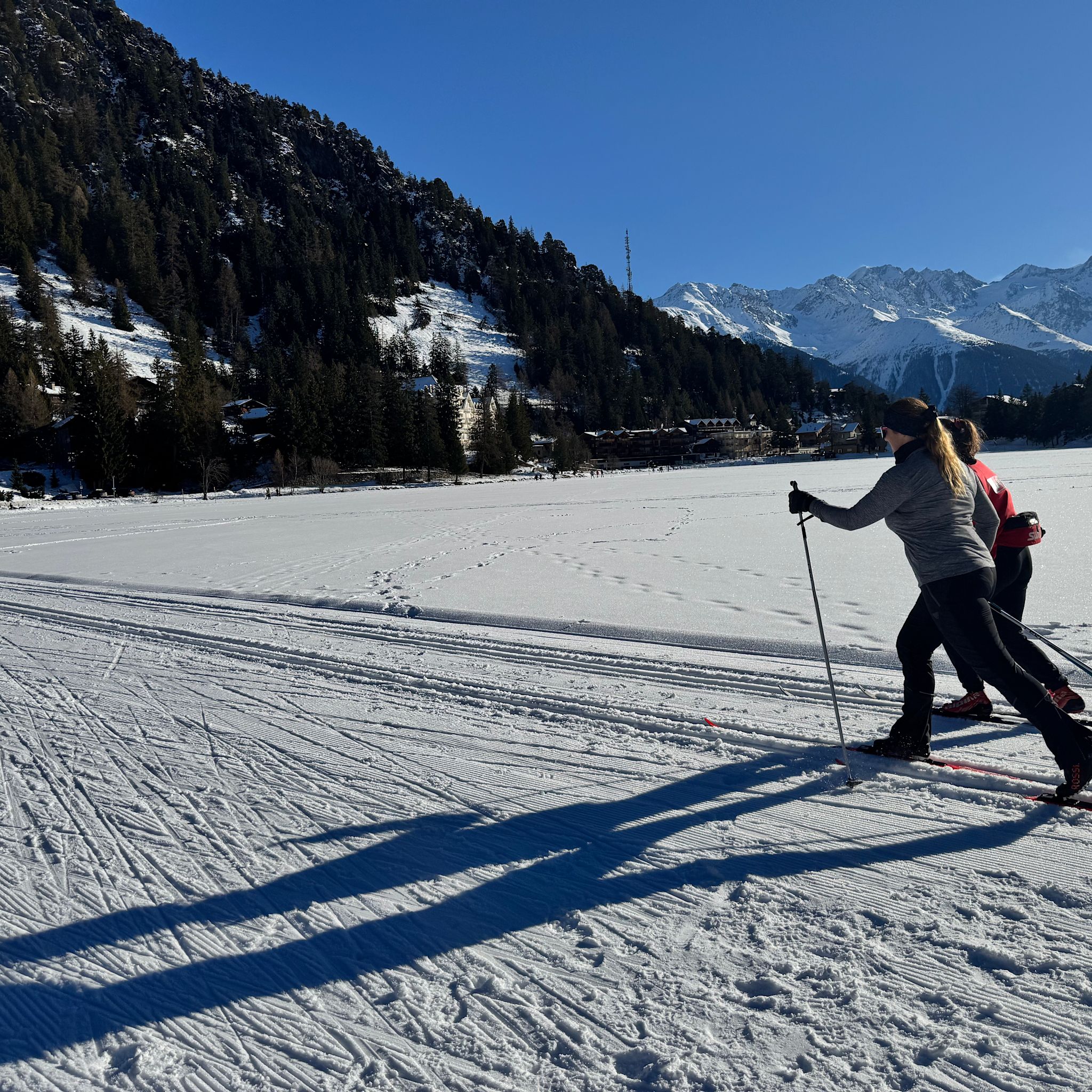 Zwei Langläufer auf einer Loipe in der winterlichen Landschaft von Champex-Lac