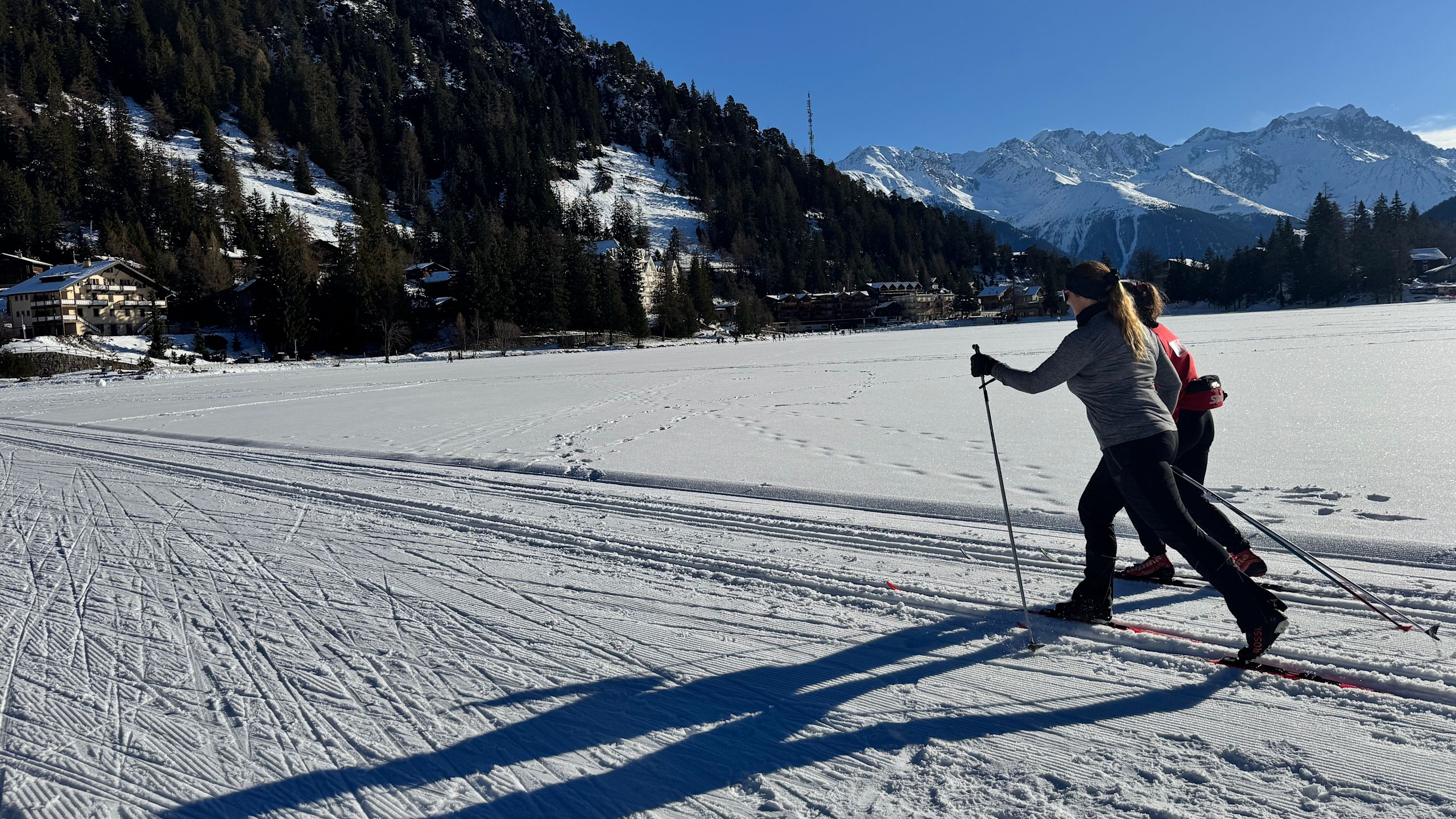 Two cross-country skiers on a trail in the winter landscape of Champex-Lac