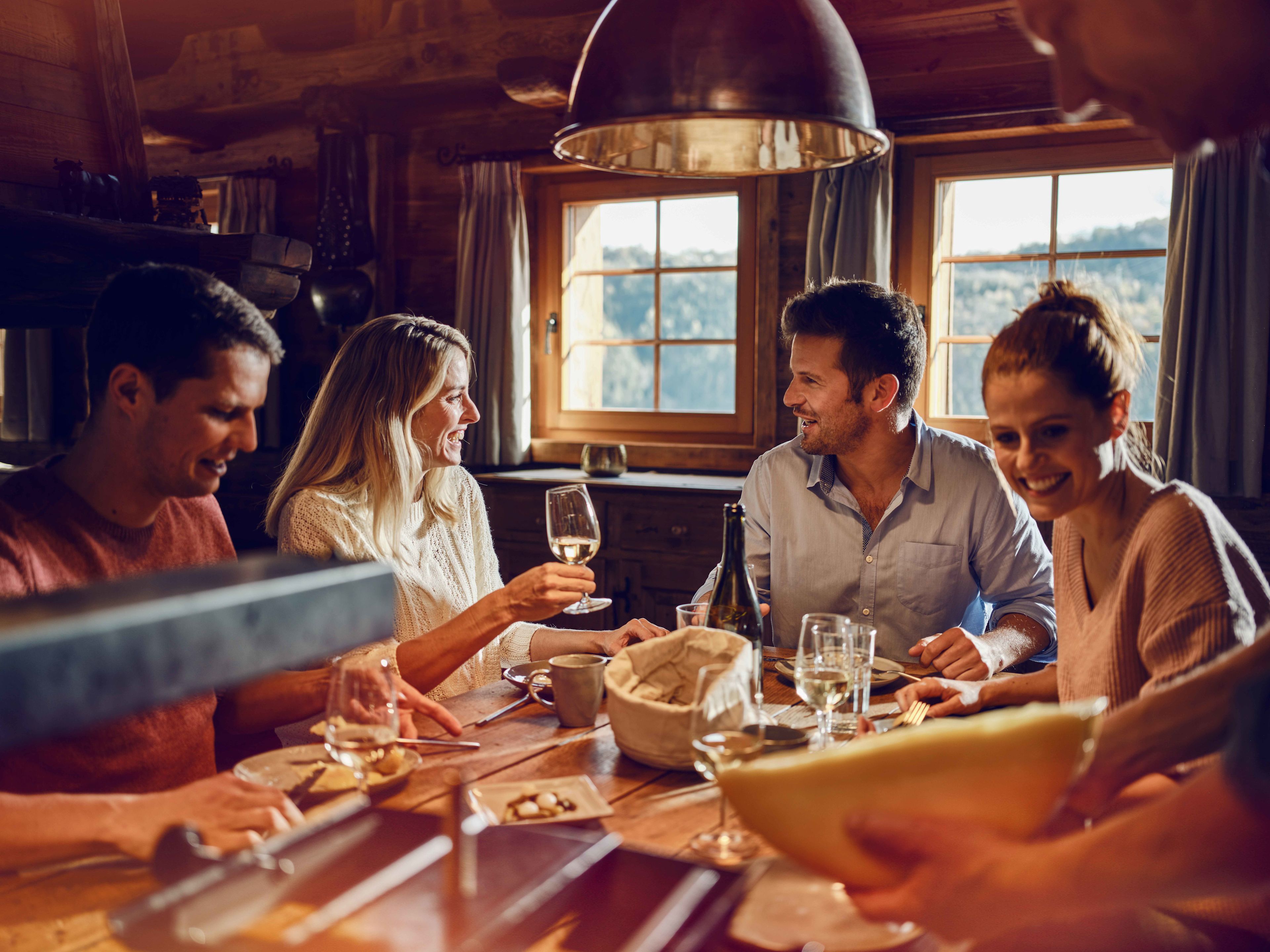 Four People Enjoying Food in a Chalet , Valais, Switzerland