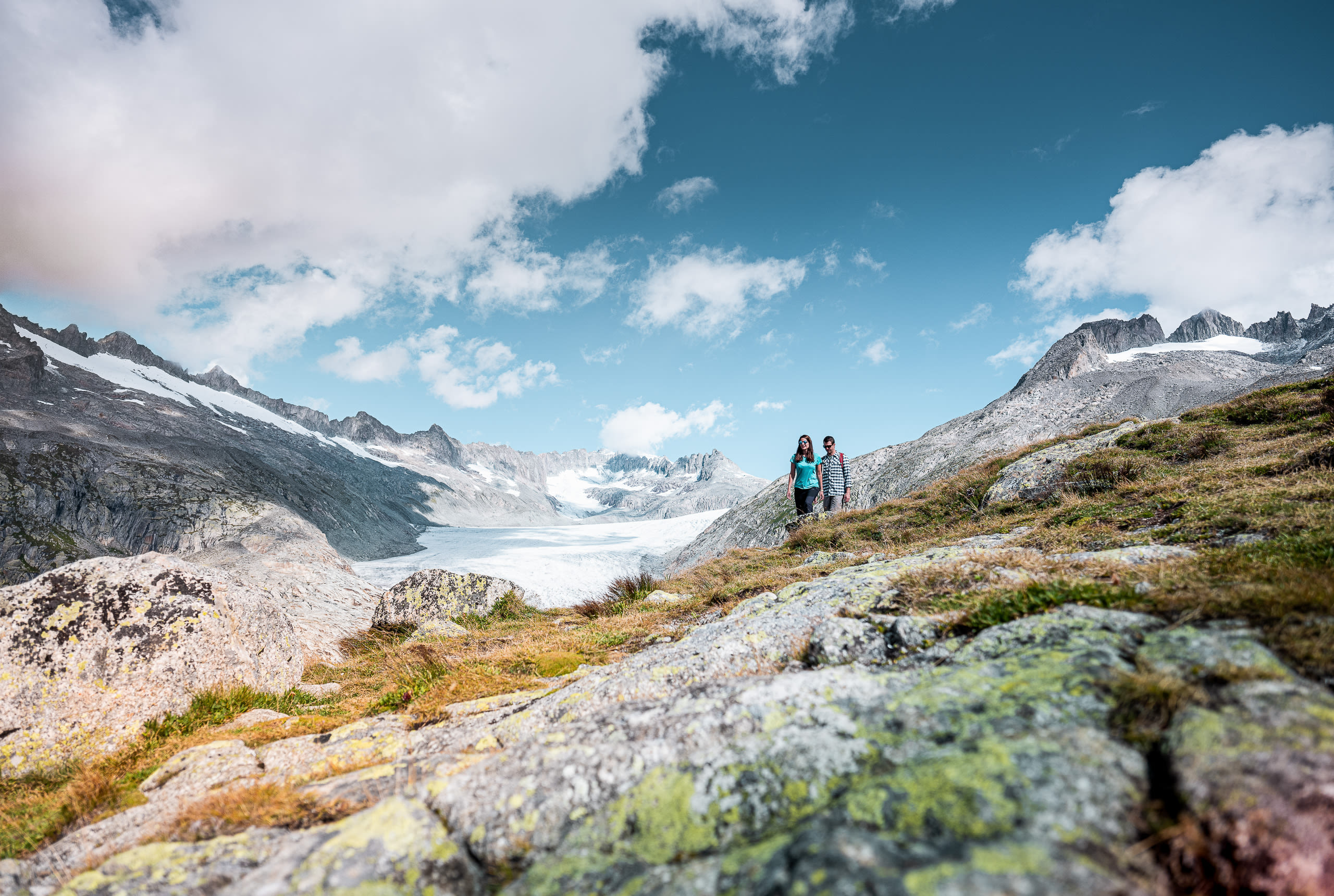 Two people admiring the beautiful view in Obergoms in Valais, Switzerland.