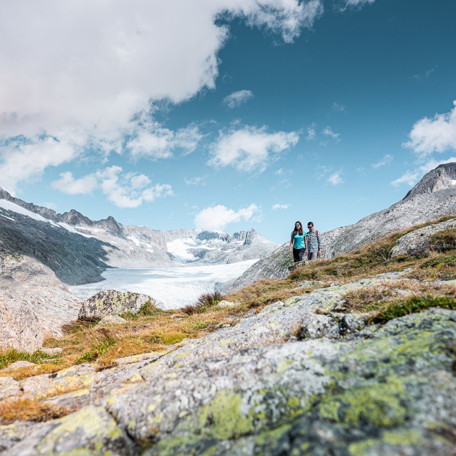 Zwei Personen bewundern die schöne Aussicht im Obergoms, Wallis, Schweiz.