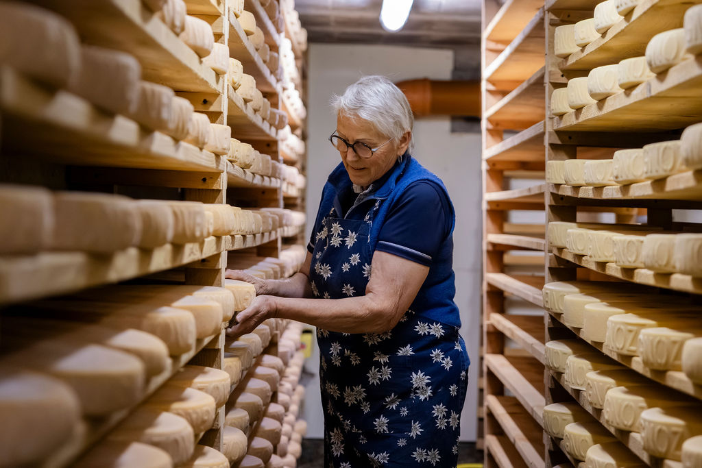 Lise Es-Borrat, a farmer in Val d’Hérens, tending raclette cheese and tommes in the cheese cellar of Loveignoz pasture