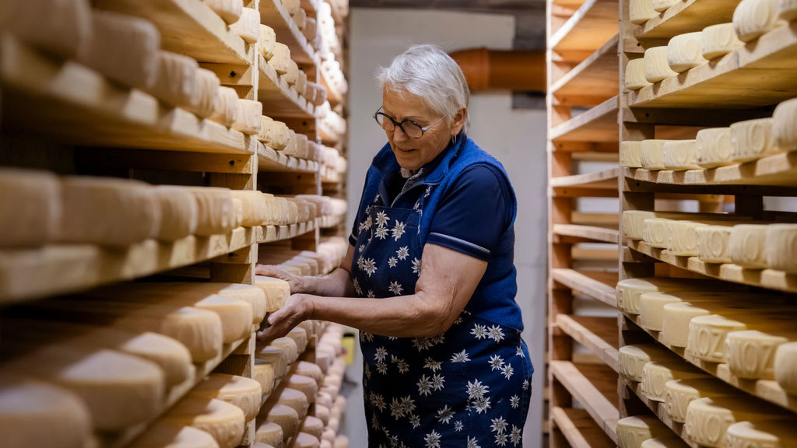 Lise Es-Borrat, a farmer in Val d’Hérens, tending raclette cheese and tommes in the cheese cellar of Loveignoz pasture