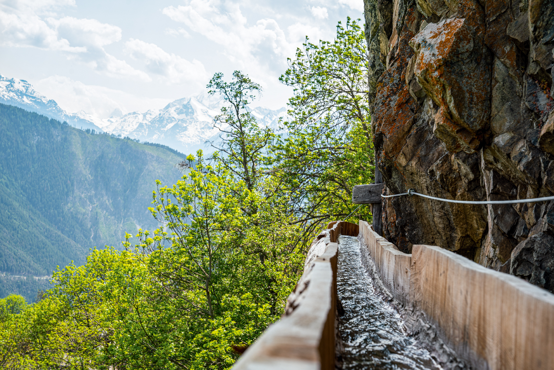 Un bisse au-dessus du village de Mund dans un canal en bois le long du rocher proéminent.