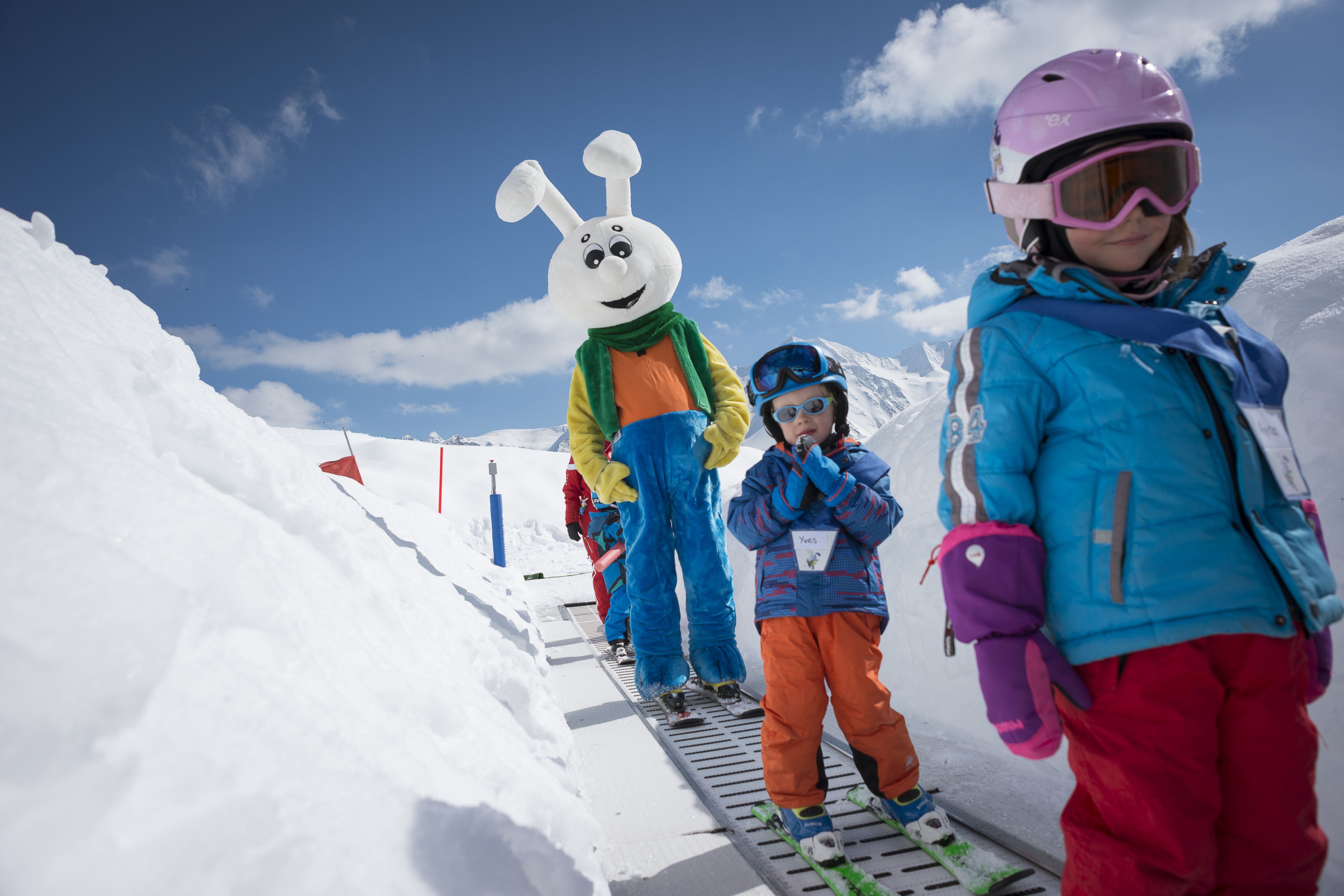 Snowli, la mascotte du jardin des neiges, accompagne les enfants sur le tapis magique, un téléski qui les mène au sommet de la mini-piste