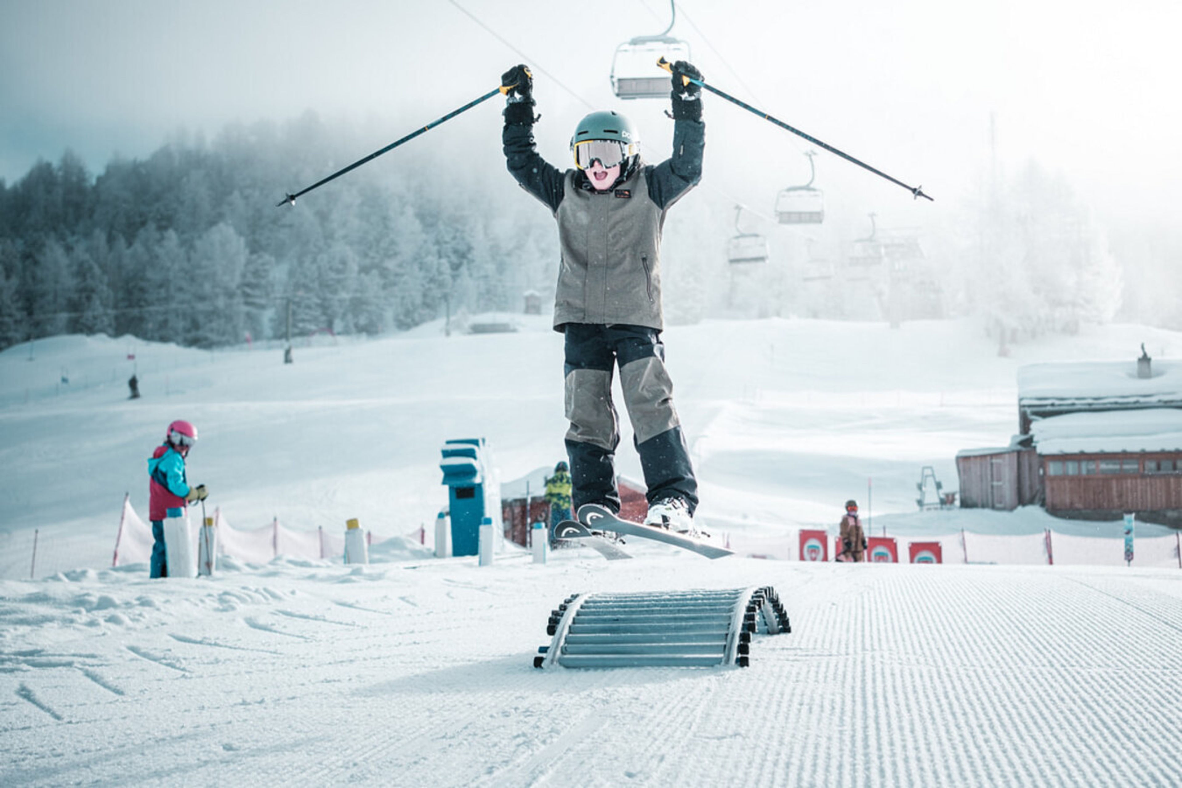 A child jumps over an obstacle in the Talentschmiede ski garden on the Hannigalp in Grächen, an ideal place for playful ski learning.